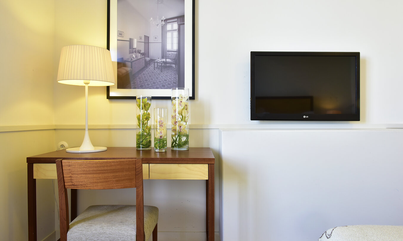 The Classic Room of The Serra da Estrela Inn has two beds, a desk with a chair, and a window