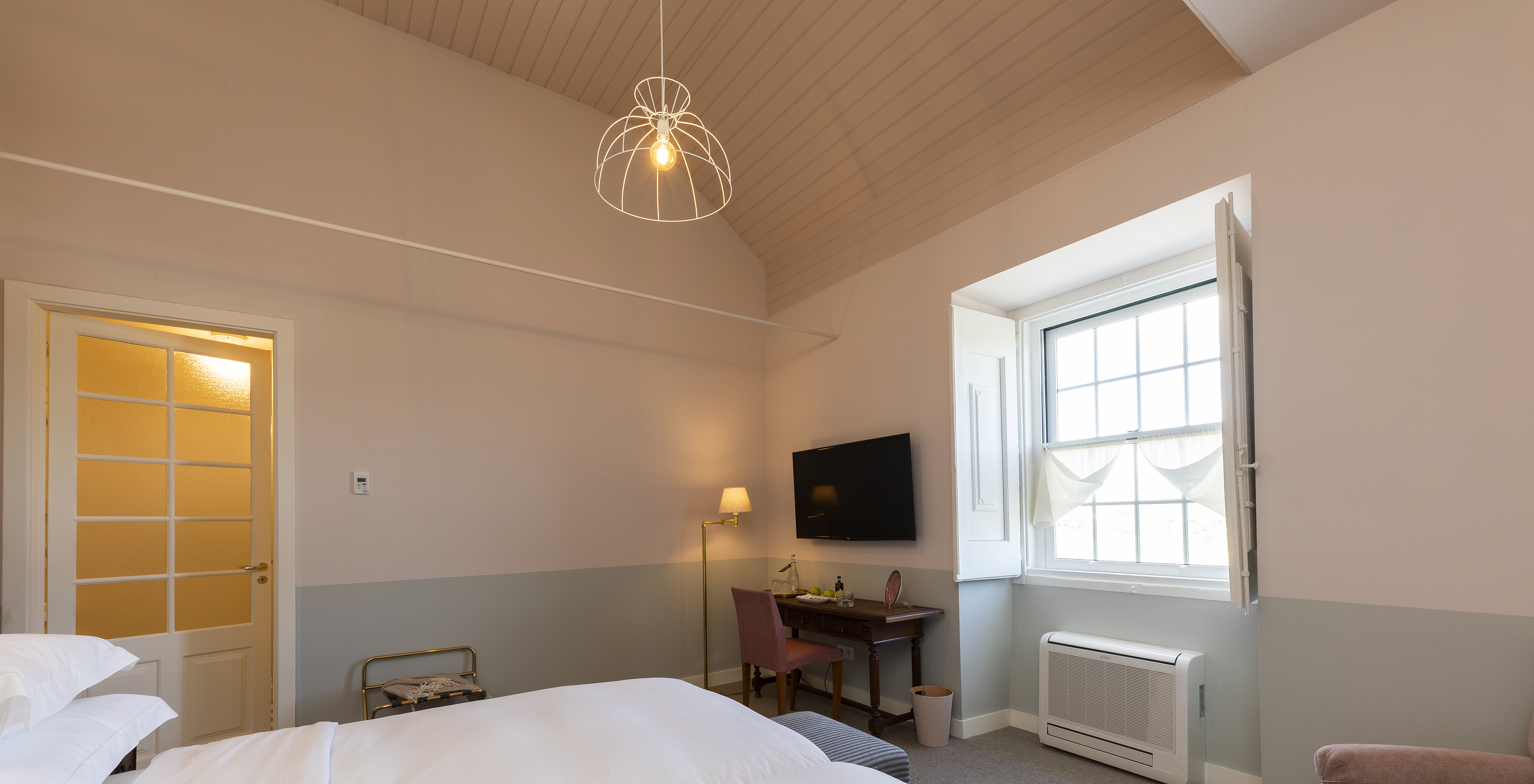 The Superior Room of The Pousada Vila Óbidos has a ceiling lamp and two beds with a window and a television in front
