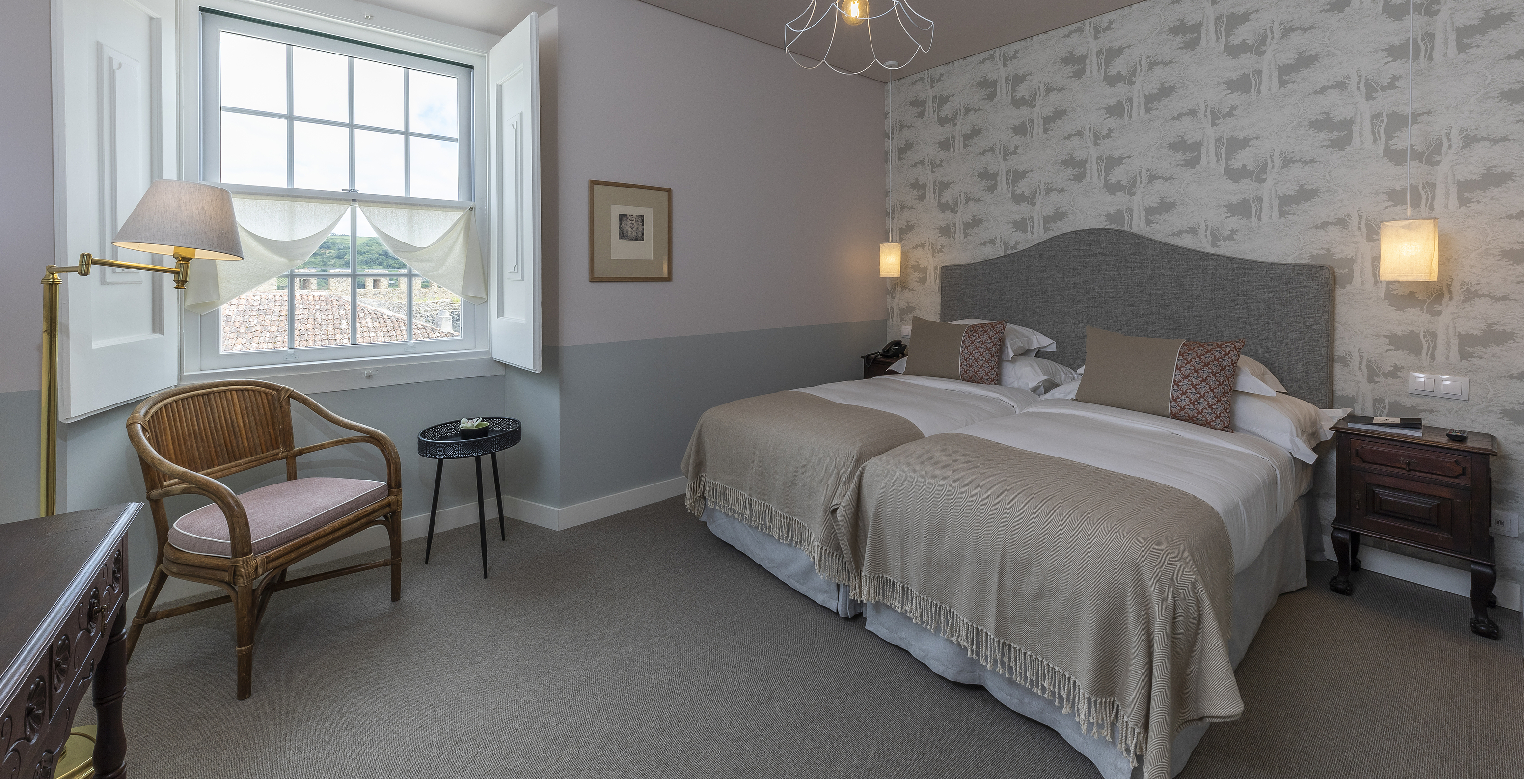 The Superior Room of The Pousada Vila Óbidos has two beds, wallpaper with trees in gray tones, and a window