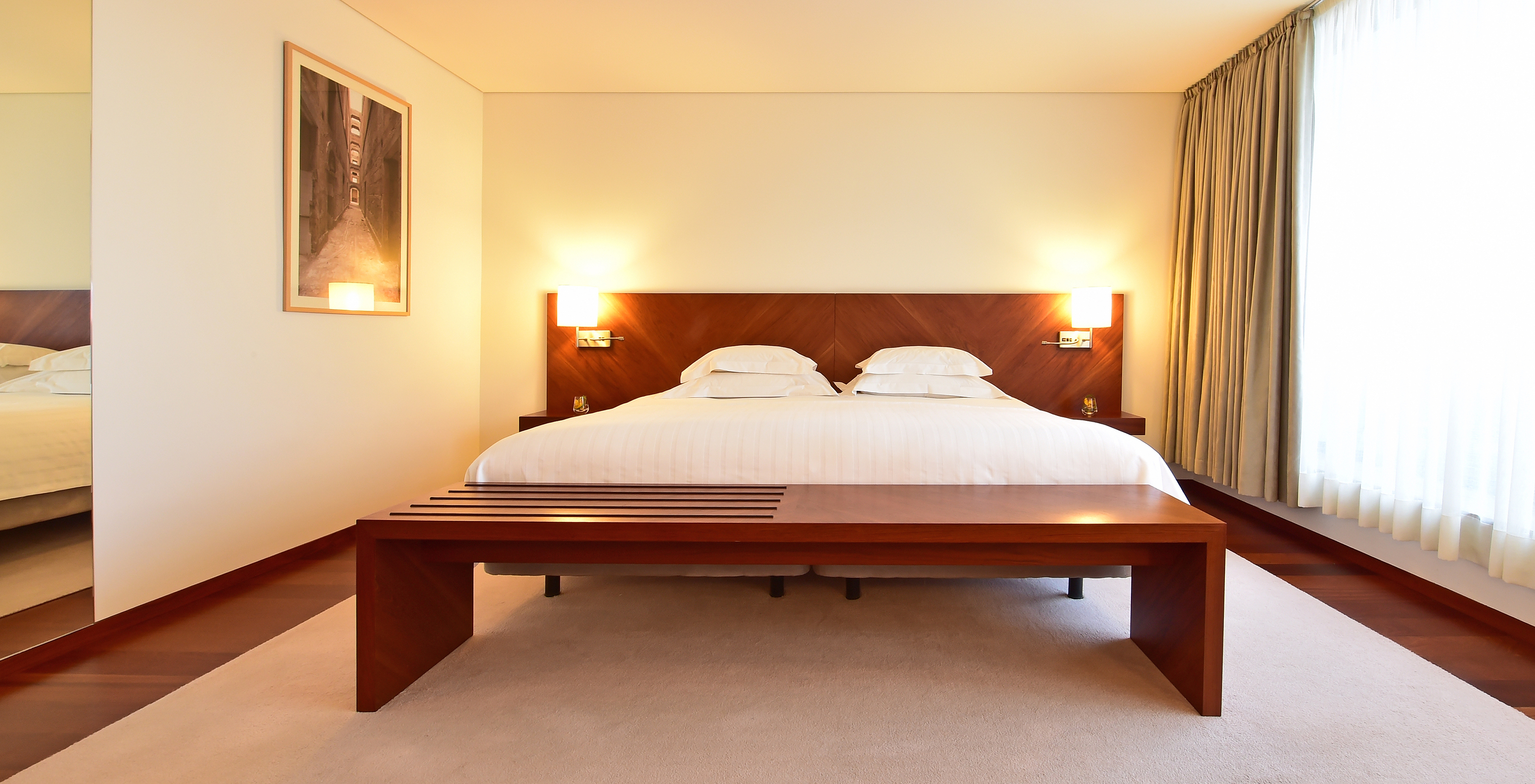 The Superior Room of the Pousada Viseu has a double bed and bedside table with lamp on each side