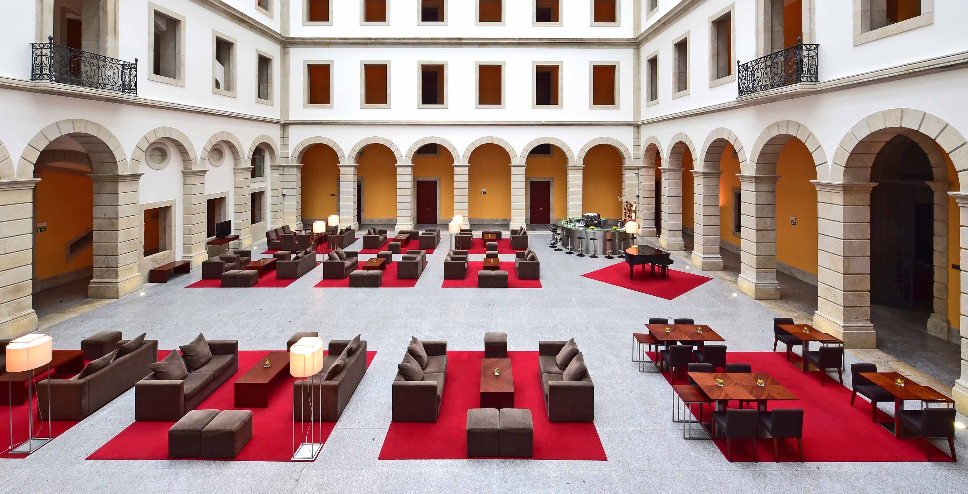 Bar of Pousada Viseu, historic hotel with arches and sofas, and a bar at the back