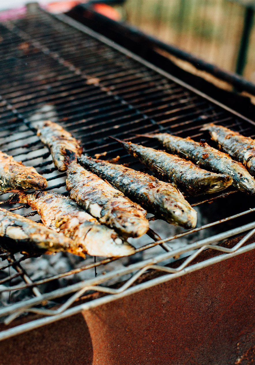Grilled sardines cooking over an outdoor charcoal grill at a Lisbon market near Pousada Alfama, Hotel no Centro de Lisboa