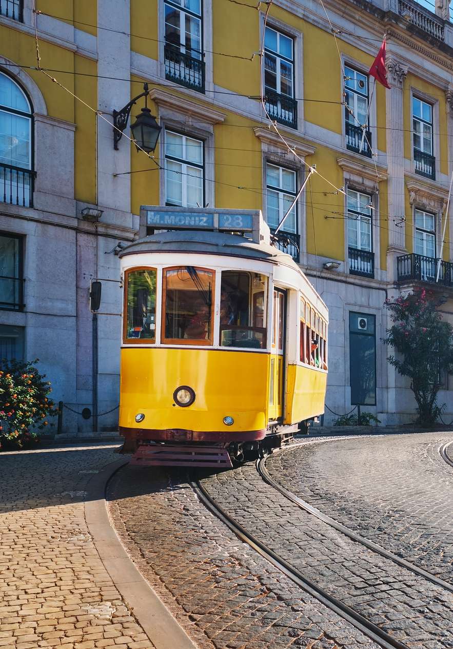 Historic Lisbon tram near Pousada Queluz, Hotel Histórico em Queluz, passing yellow buildings on cobbled street