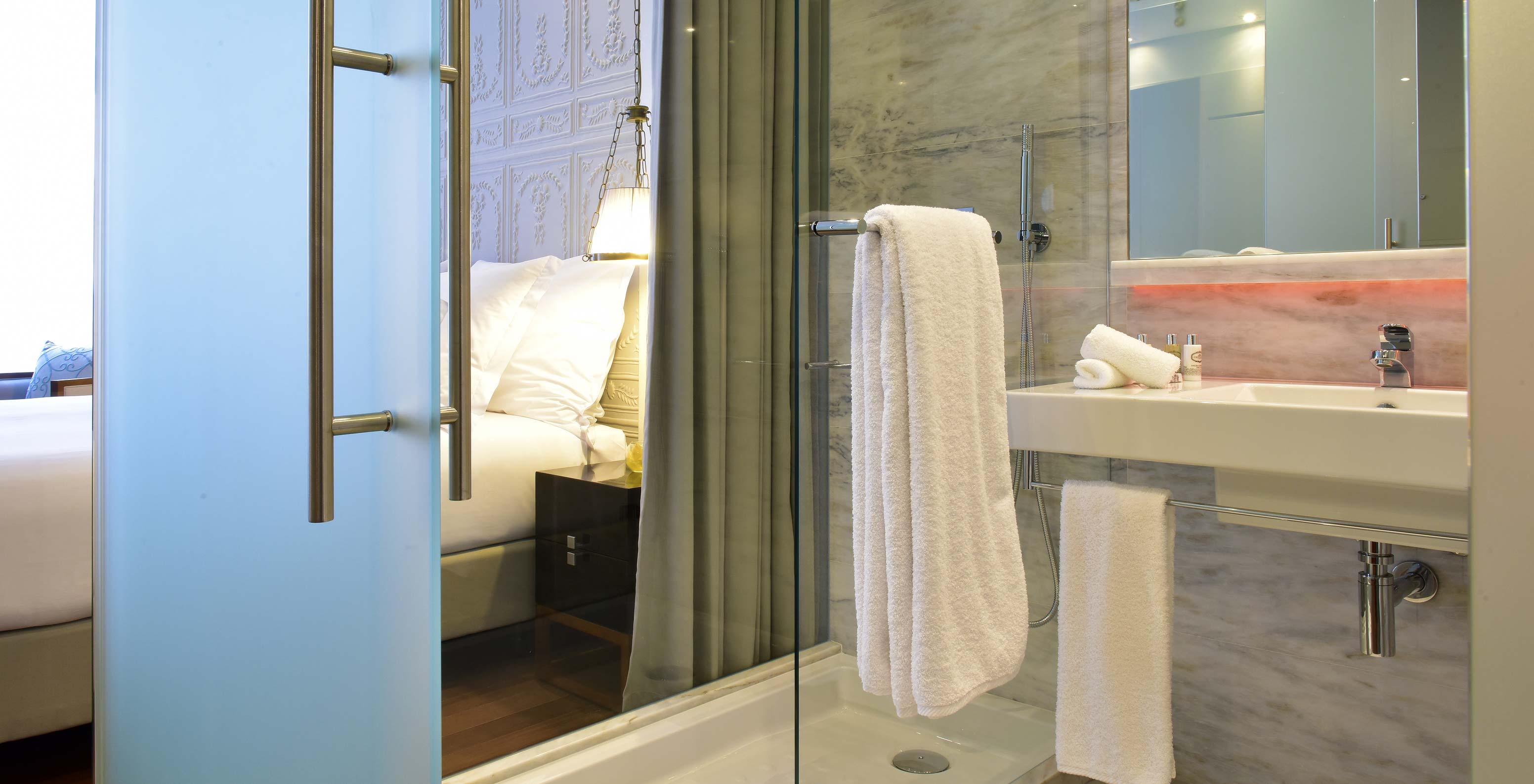 The Deluxe King Size Bed at Pousada de Lisboa Praça do Comércio has bathroom with shower, sink, mirror and white towel