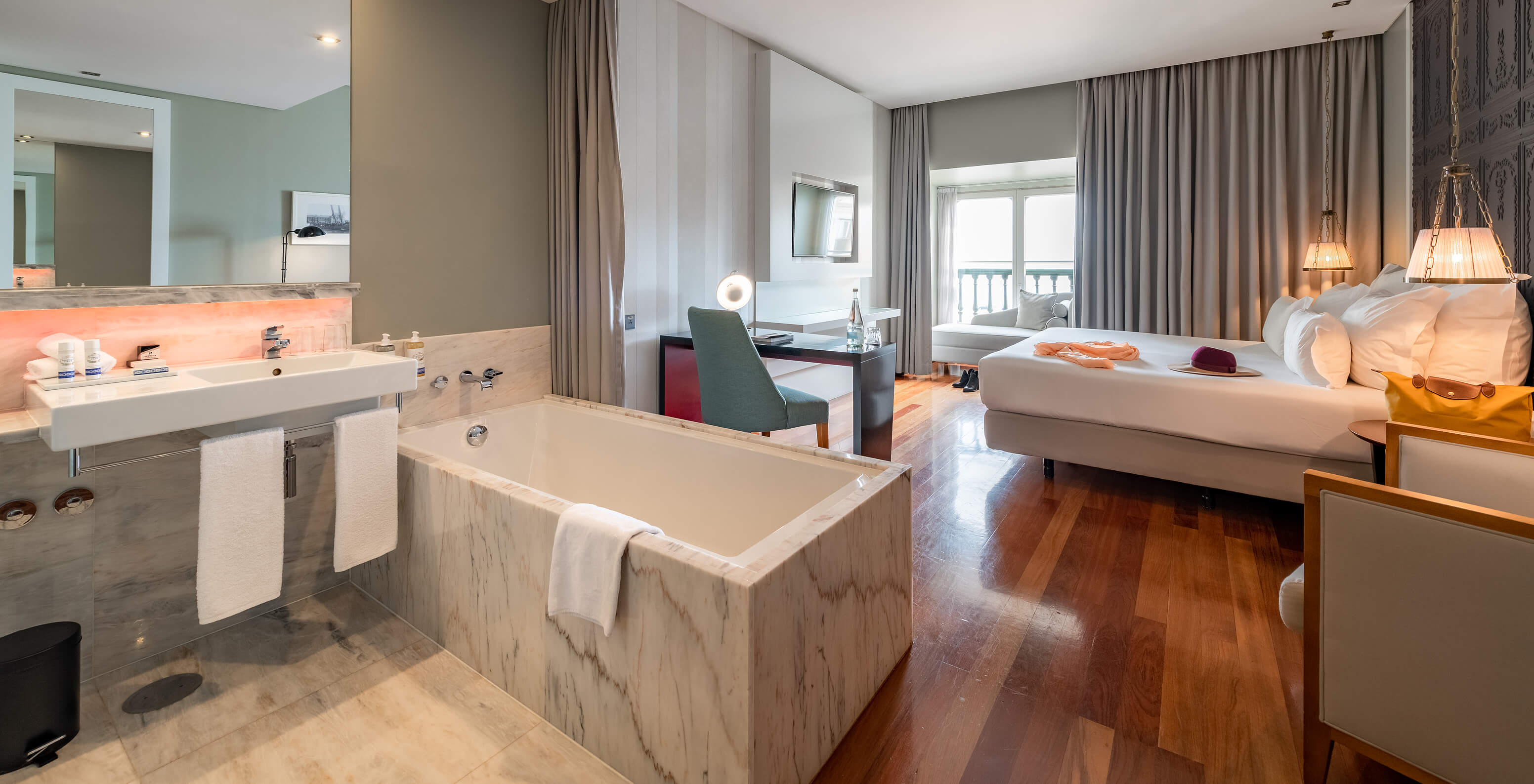 The Premium King Size Bed at Pousada de Lisboa Praça do Comércio features a marble bathtub, desk, bed, and window