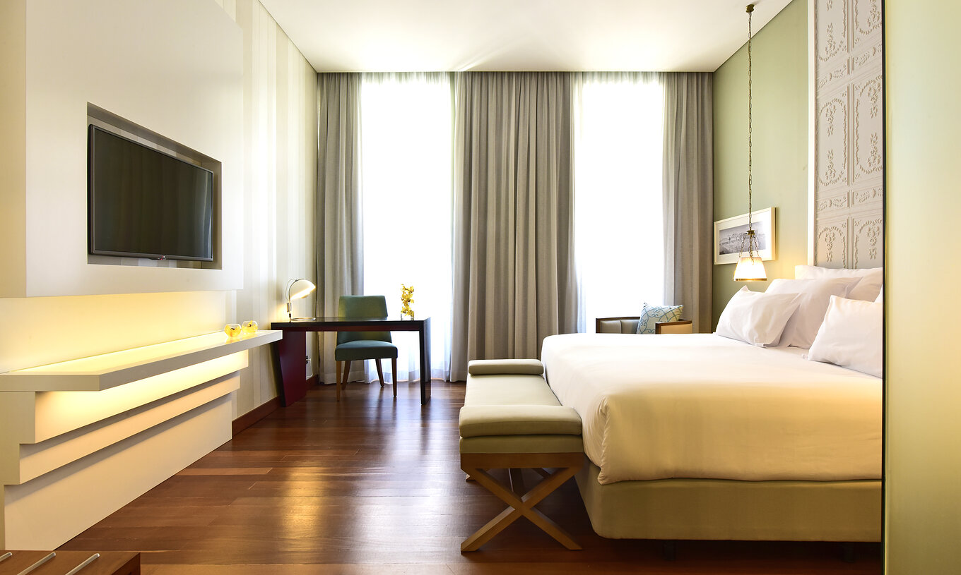 The Deluxe King Size Bed at Pousada de Lisboa Praça do Comércio has a double bed with stool at the foot, desk, window and TV