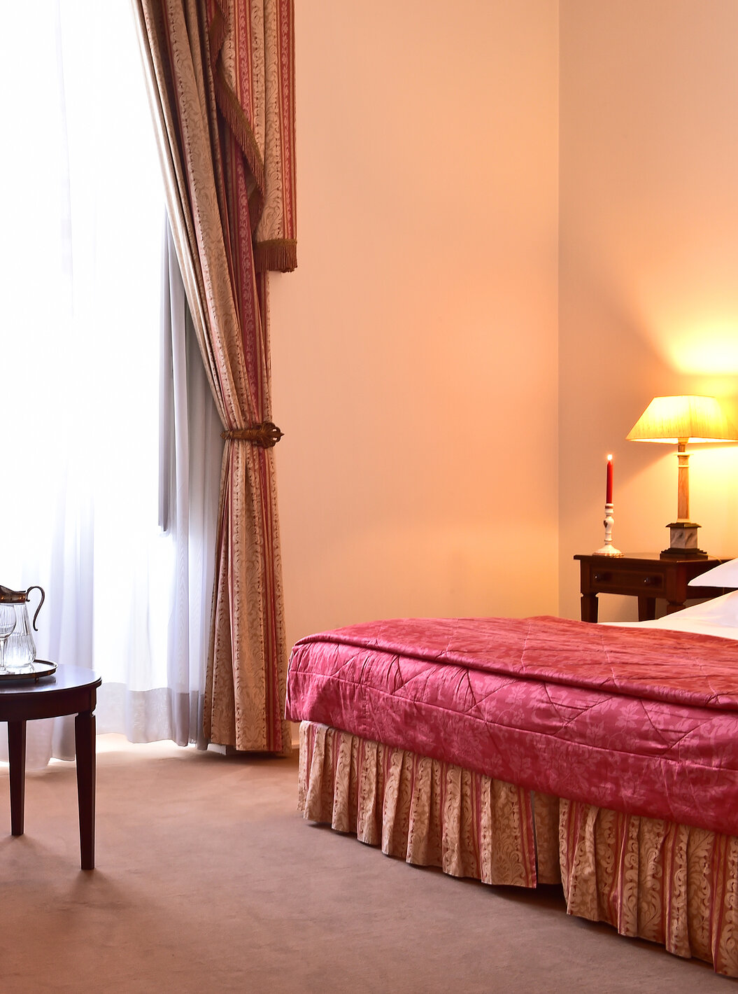 The Standard Suite of The Pousada Palácio Queluz features an armchair and a table near the bed and window where you can rest