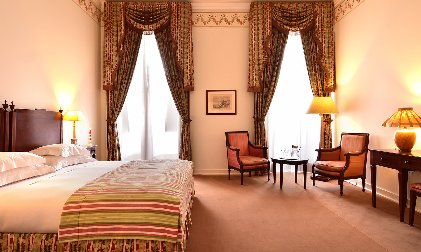 The Superior Room of The Pousada Palácio Queluz has ample space with two single beds, a sofa, and two chairs