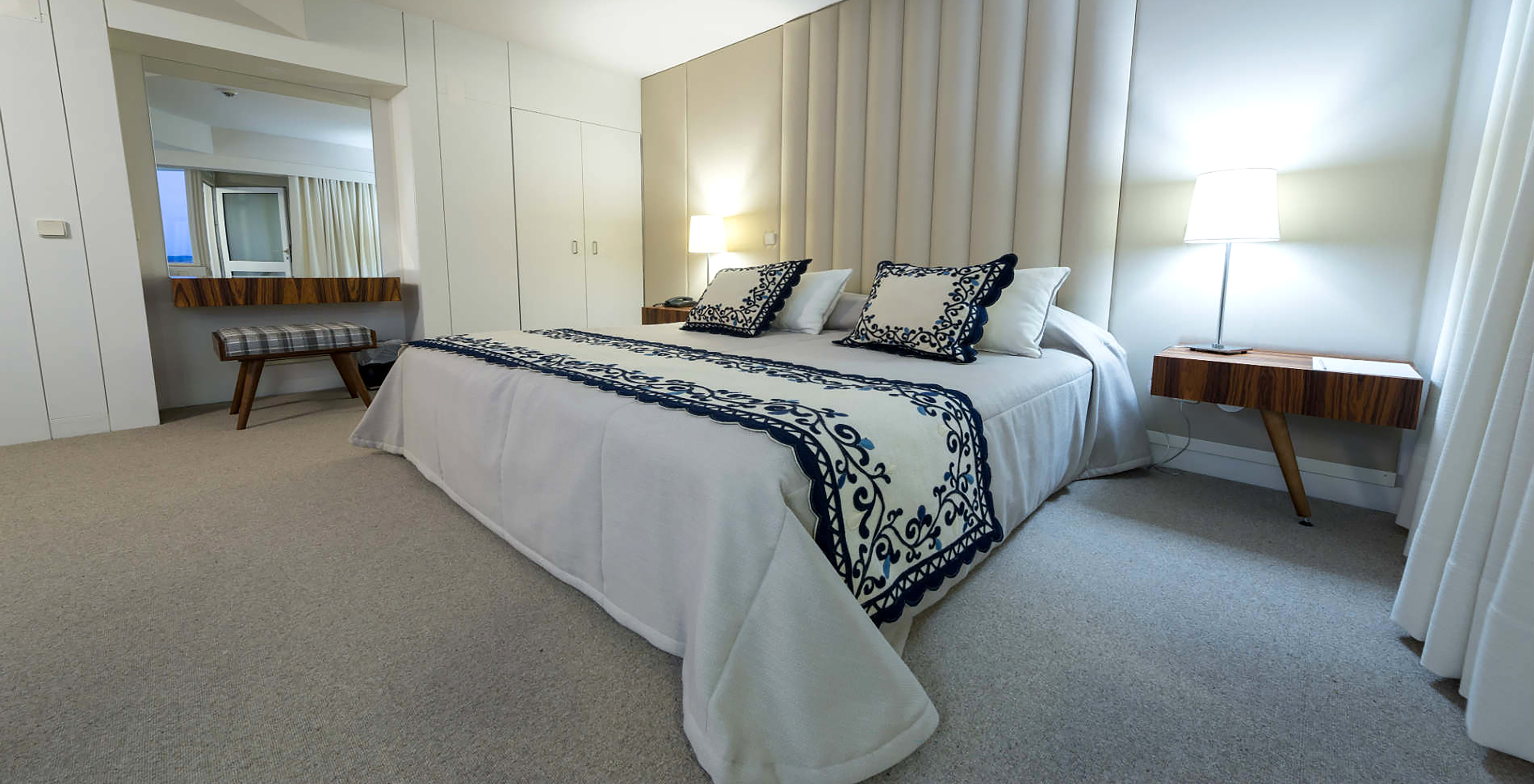 The Classic Room at Pousada Bragança has a double bed, bedside table with lamp, and a built-in wardrobe