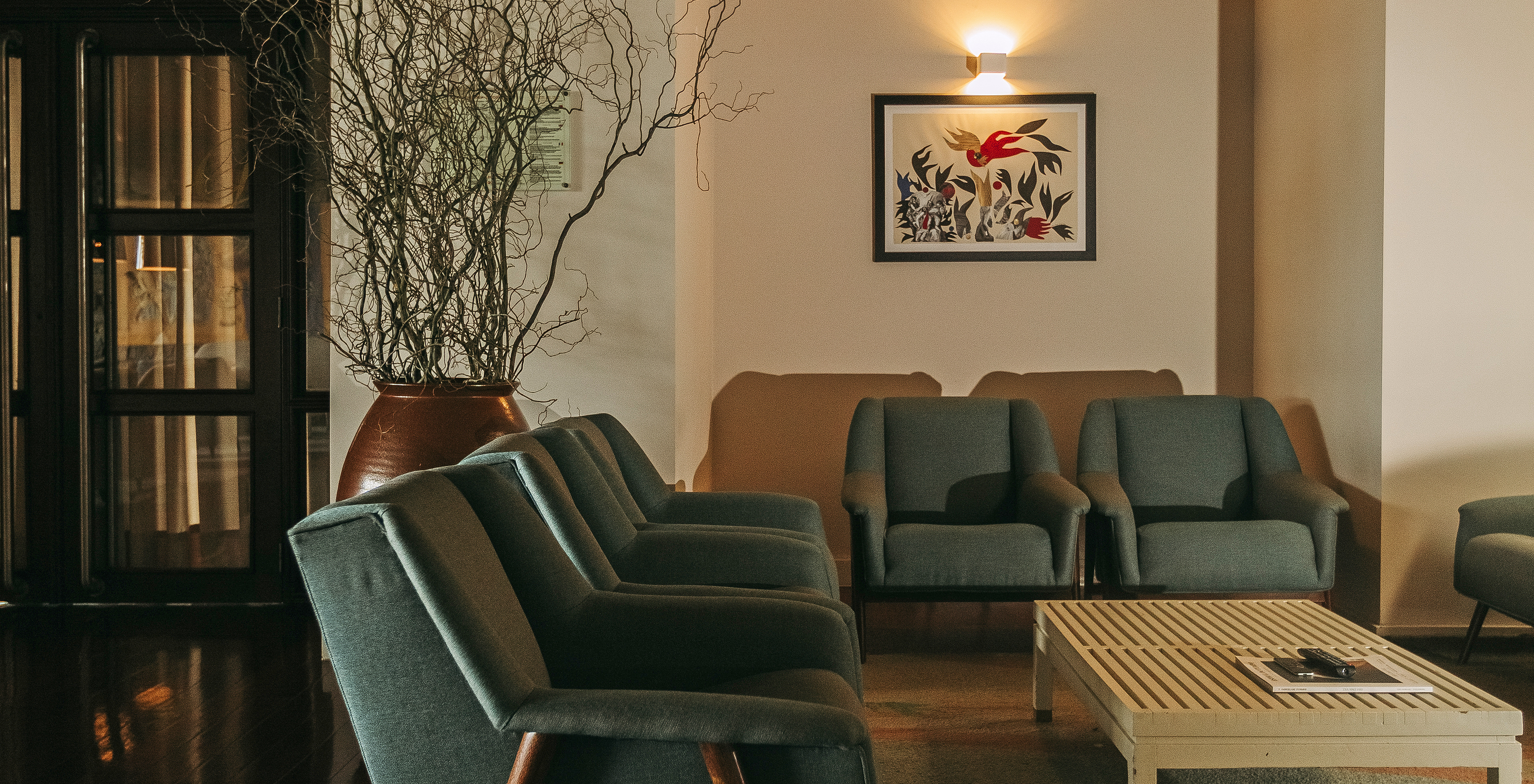Pousada Bragança, a hotel in the north, in Bragança, has a living room with blue armchairs, coffee table, and a painting