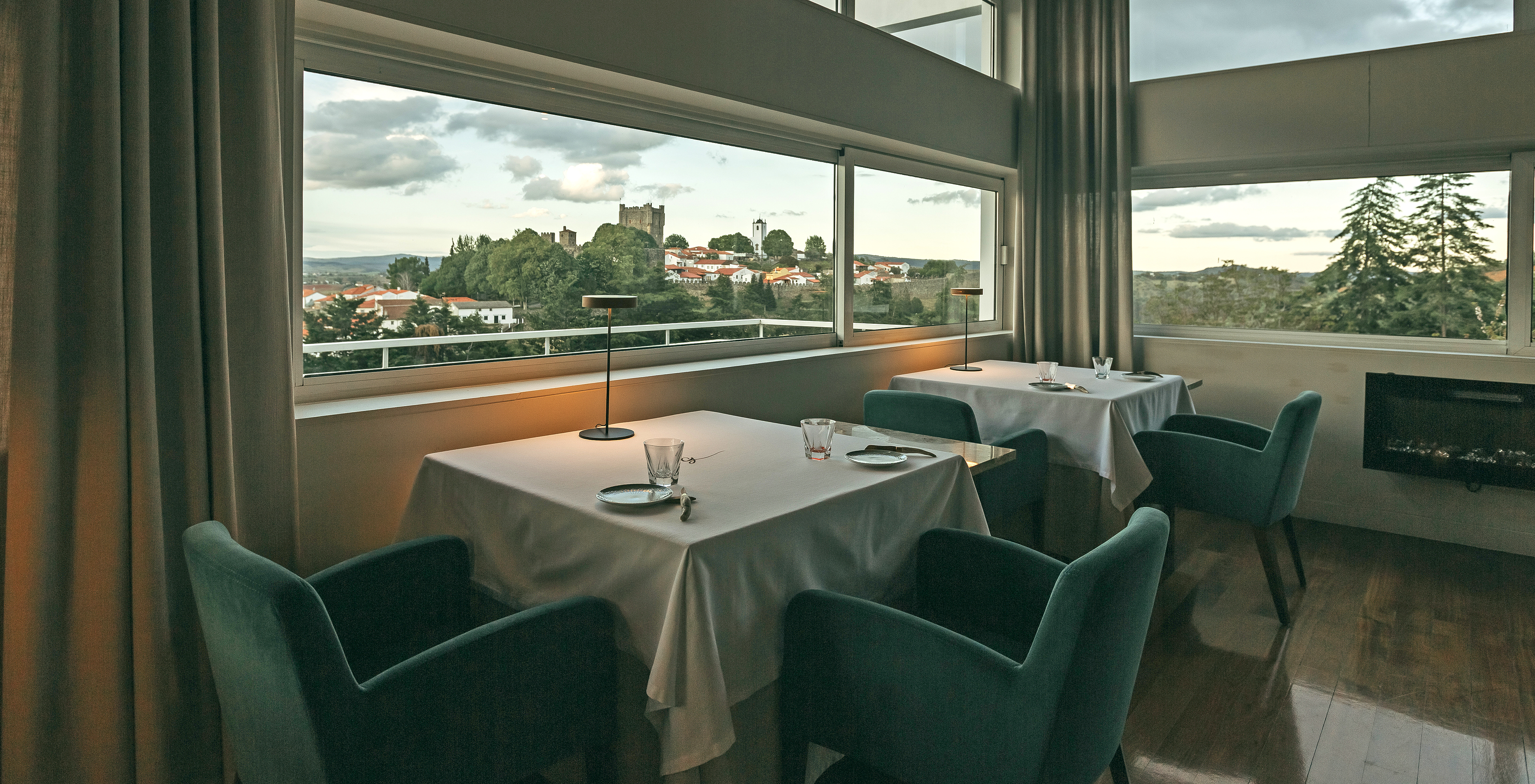 The G restaurant at the Pool Hotel in Bragança has a space with blue chairs and a table with a view