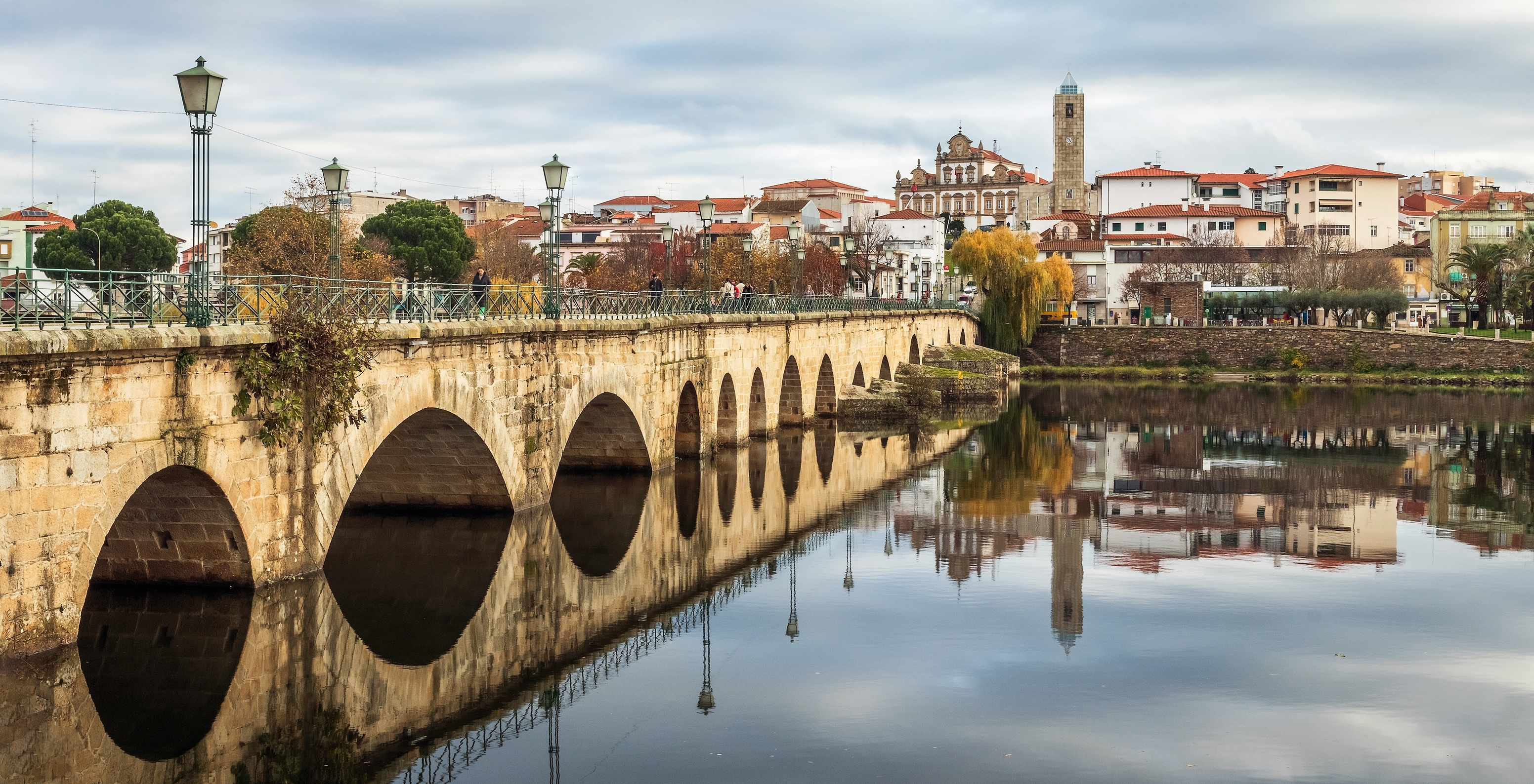 View of the Medieval Bridge of Mirandela on a calm river day with the city in the background