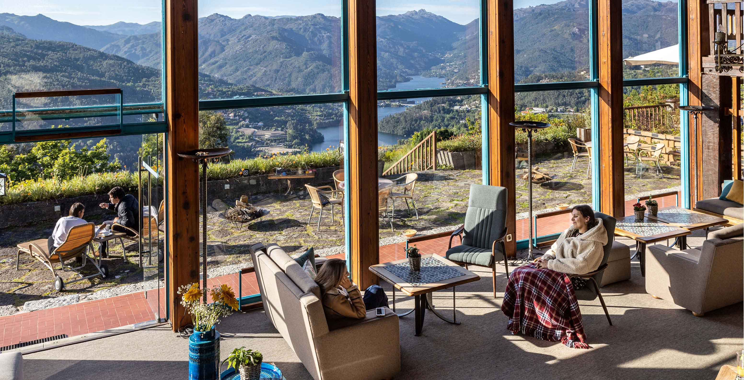 Guests enjoy the lobby while admiring the river view at Pousada Caniçada - Gerês, Mountain Hotel in Gerês
