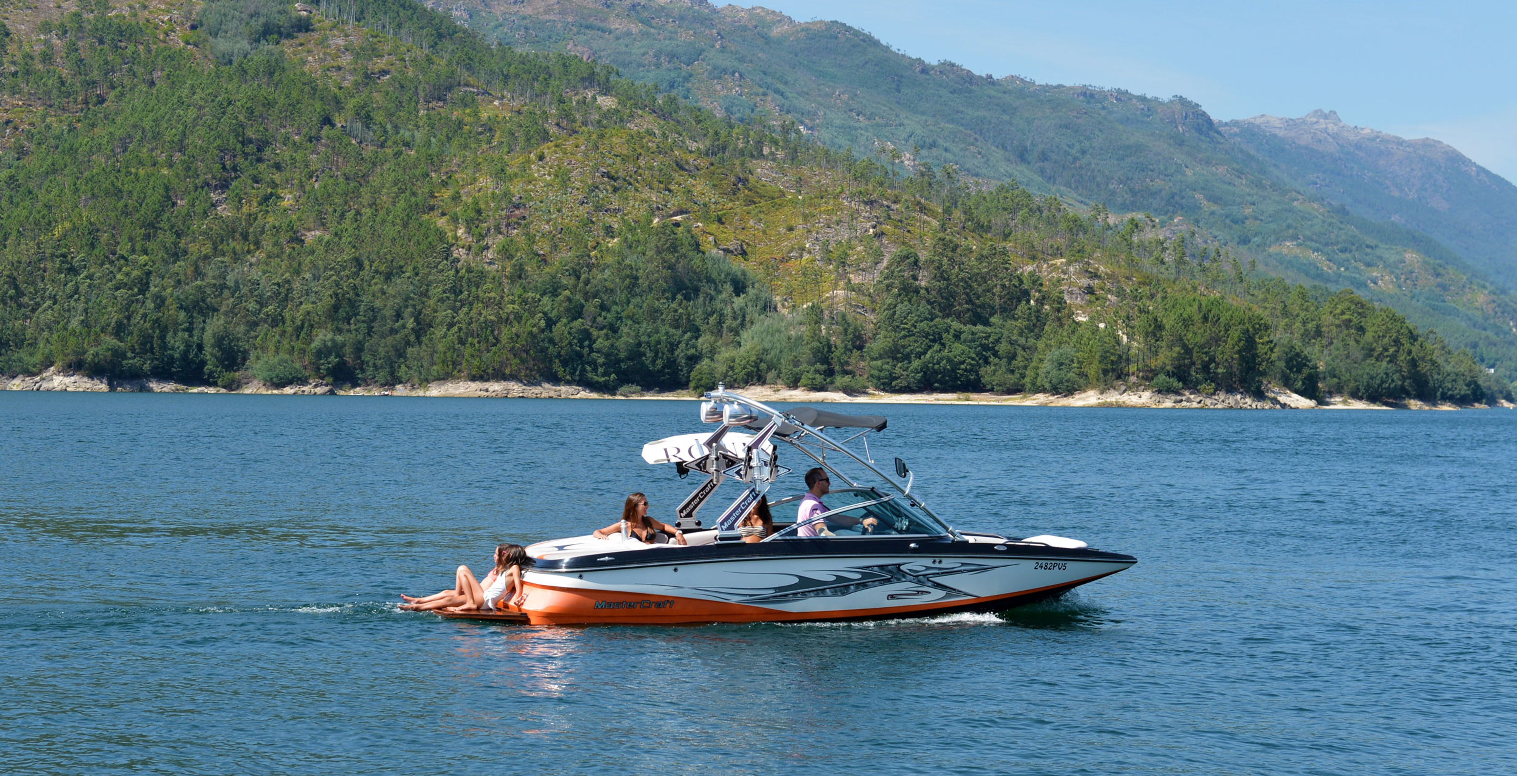 People in a boat on the Douro River in Peneda-Gerês National Park, with a mountain in the background