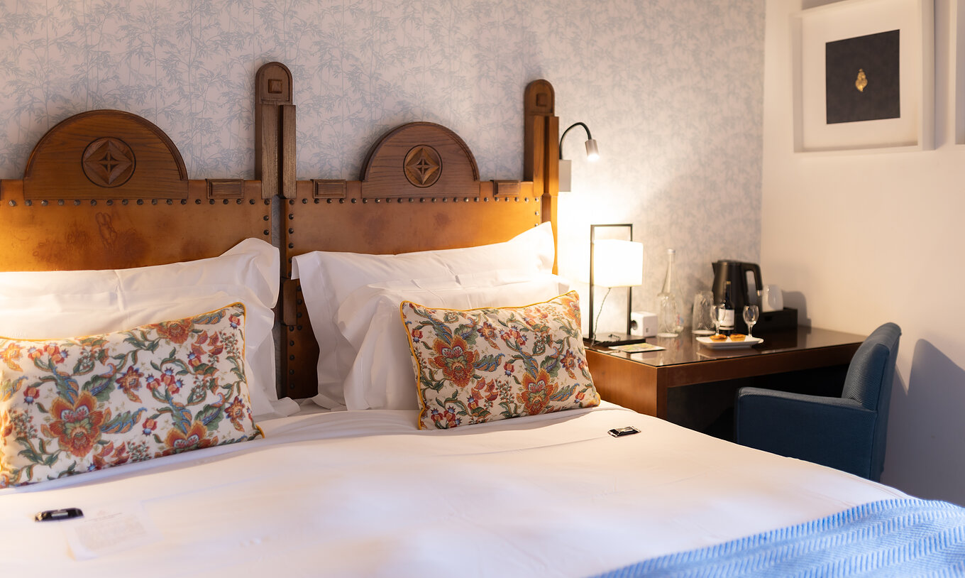The Superior Room at Pousada Caniçada - Gerês has a double bed, floral wallpaper, and a desk