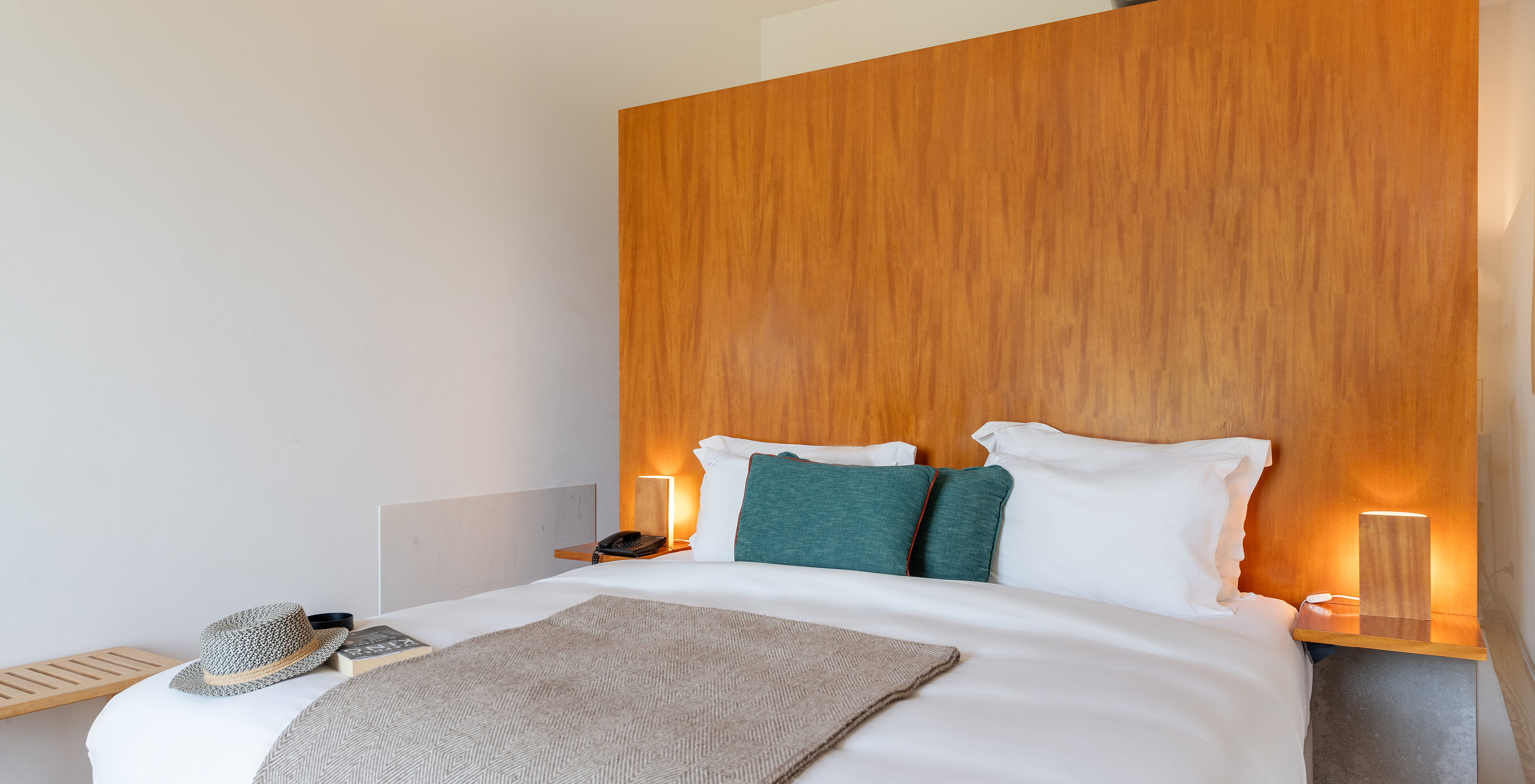 The Classic Room of The Pousada Mosteiro Amares features a double bed with a tall wooden headboard and blue cushions