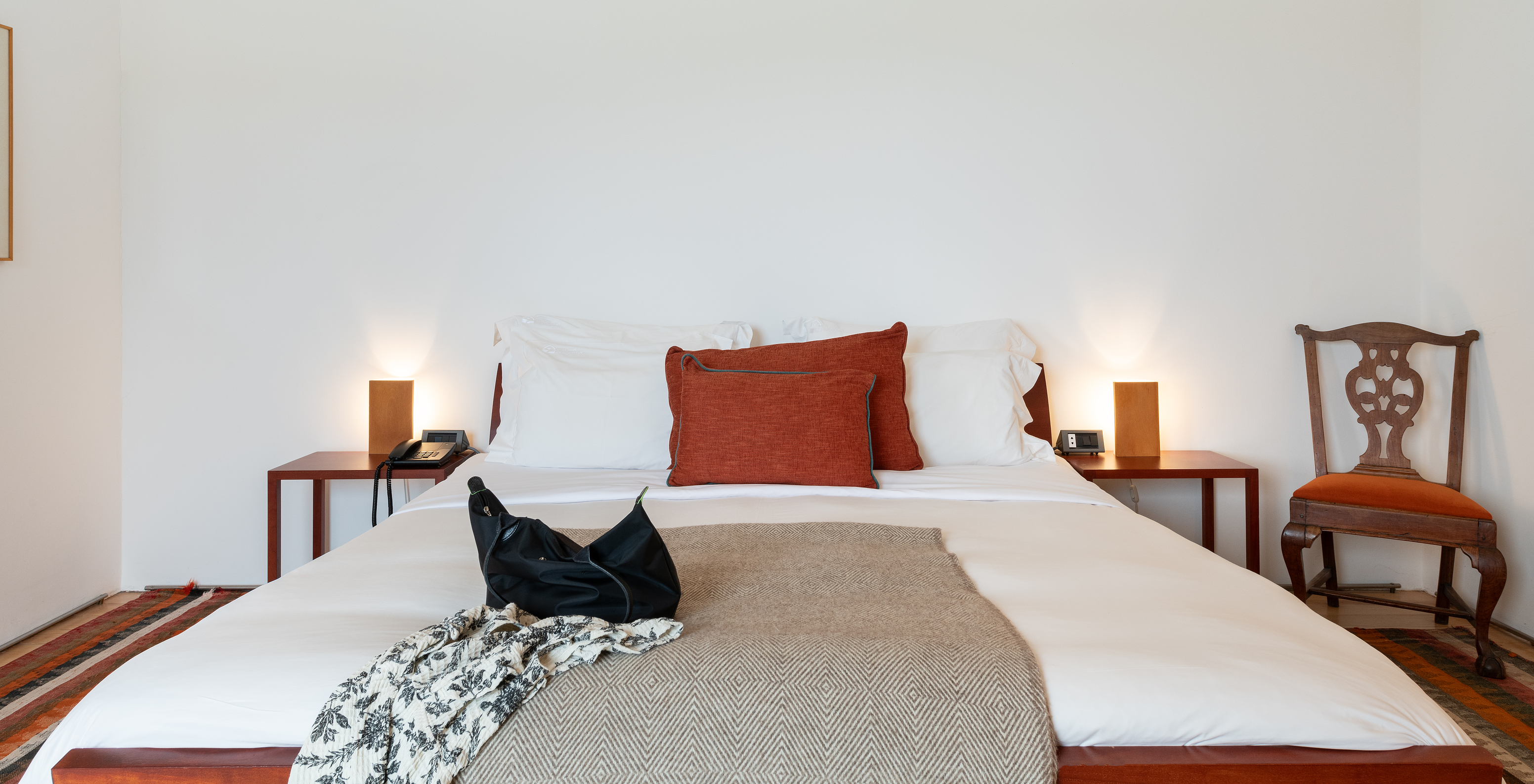 The Standard Suite of The Pousada Mosteiro Amares features a double bed, two bedside tables, and a chair