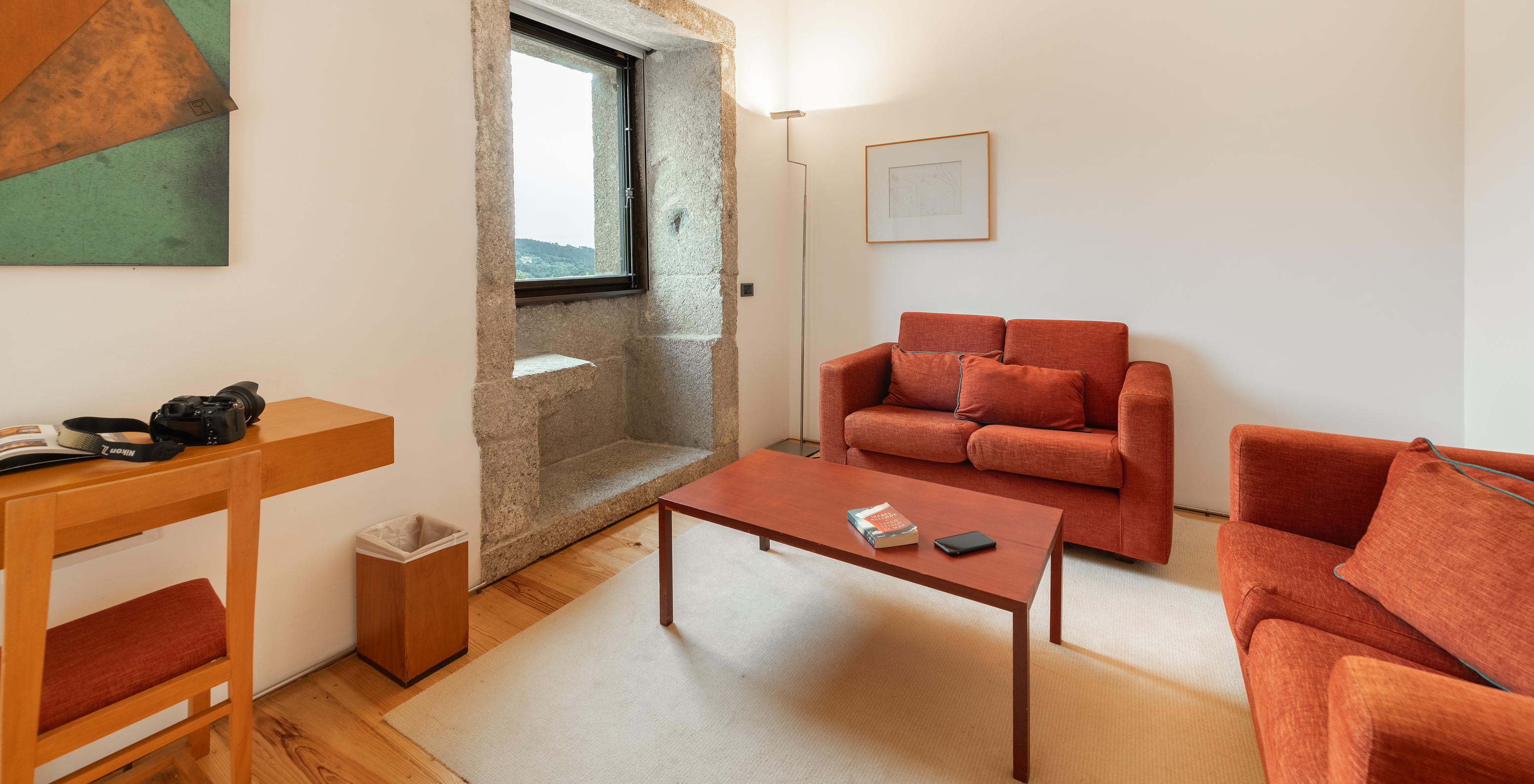 The Standard Suite of The Pousada Mosteiro Amares features a living room with red sofas and a window