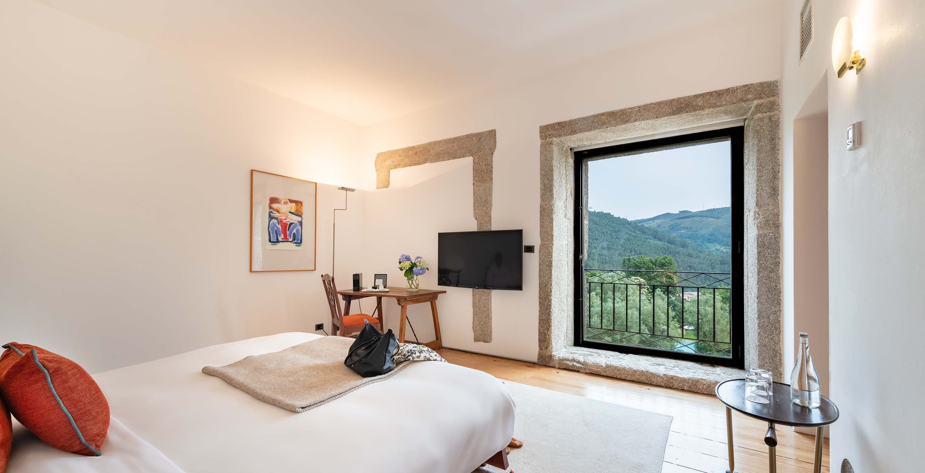 The Standard Suite of The Pousada Mosteiro Amares features a double bed with a large window with a view of nature