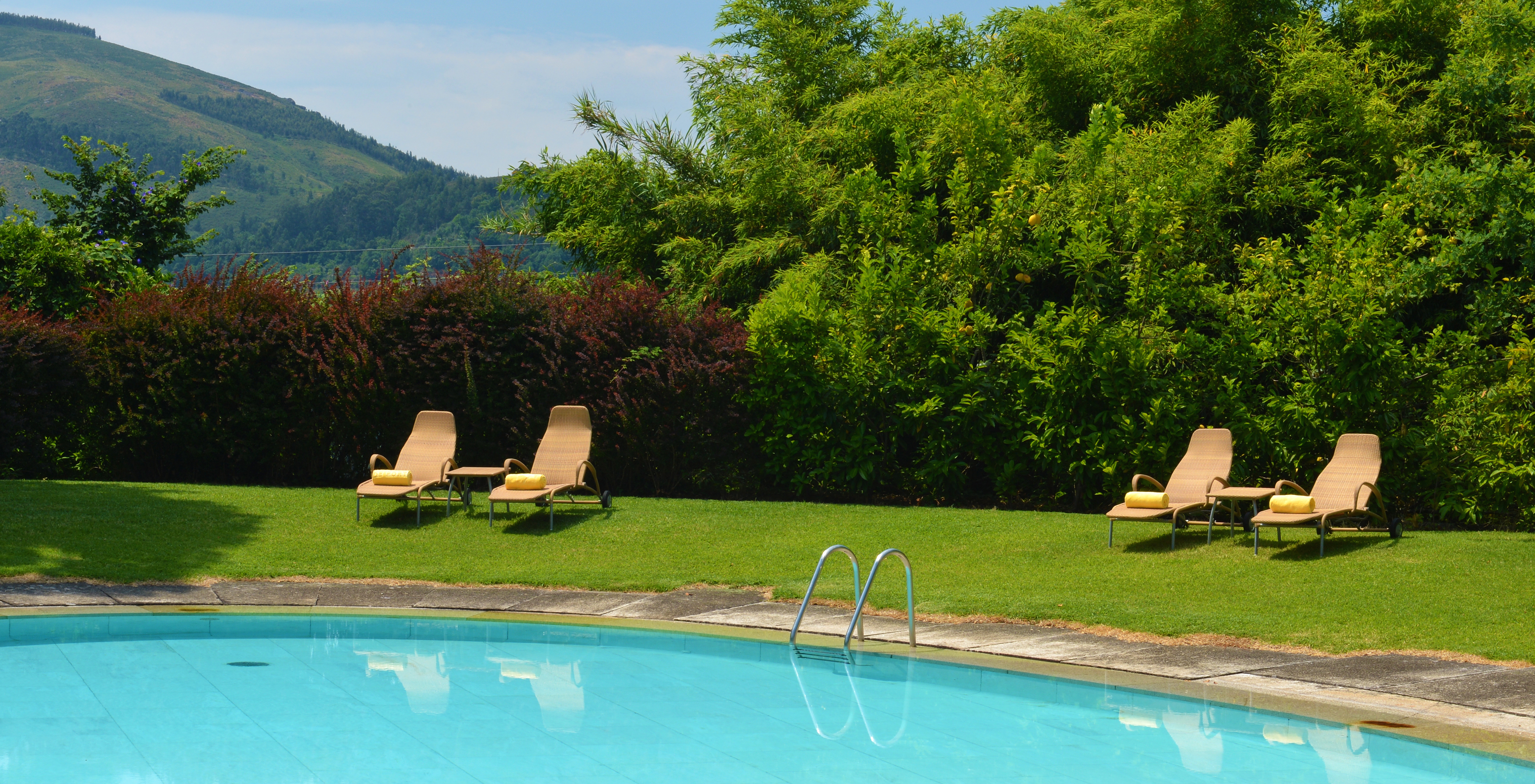 The Pousada Mosteiro Amares has an outdoor pool with sun loungers surrounded by nature