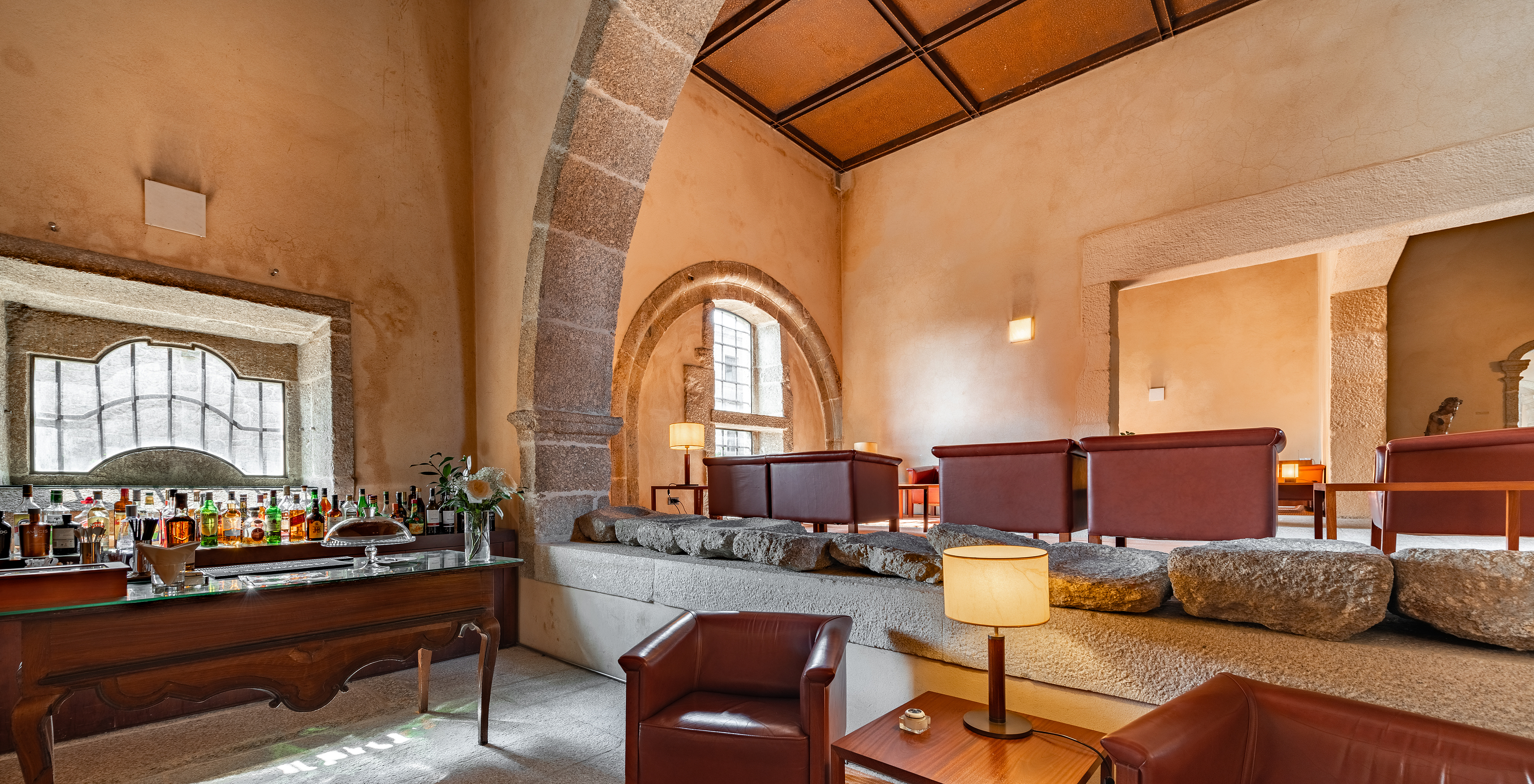 The bar at the Pousada Mosteiro Amares in the Historic Hotel in Gerês has several armchairs and a counter with drinks
