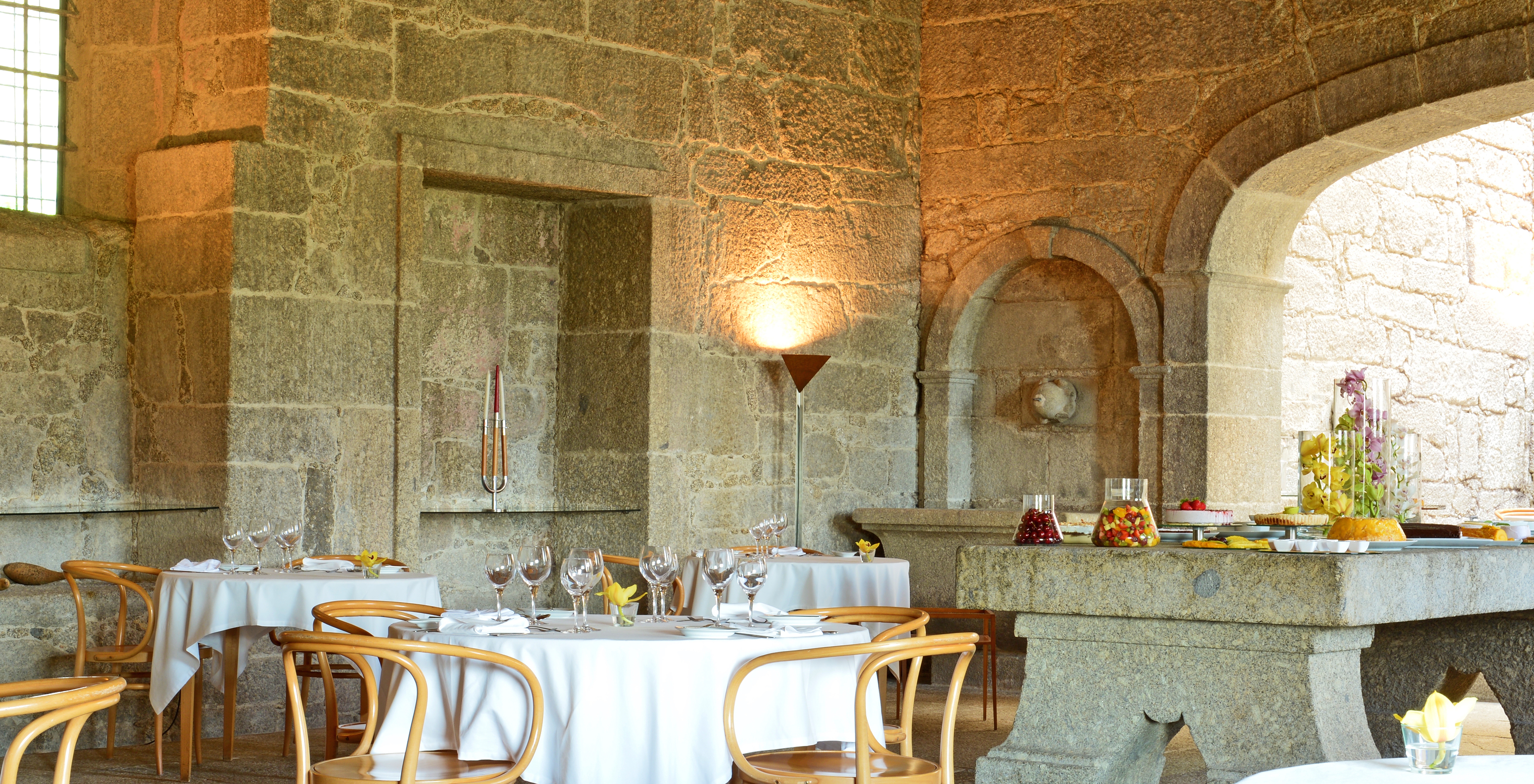 The restaurant at Pousada Mosteiro Amares in the Historic Hotel in Gerês has round tables and stone walls