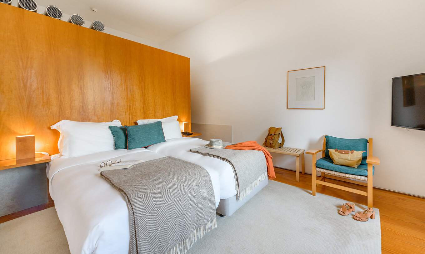 The Large Family of The Pousada Mosteiro Amares features two separate beds with a tall wooden headboard and blue cushions