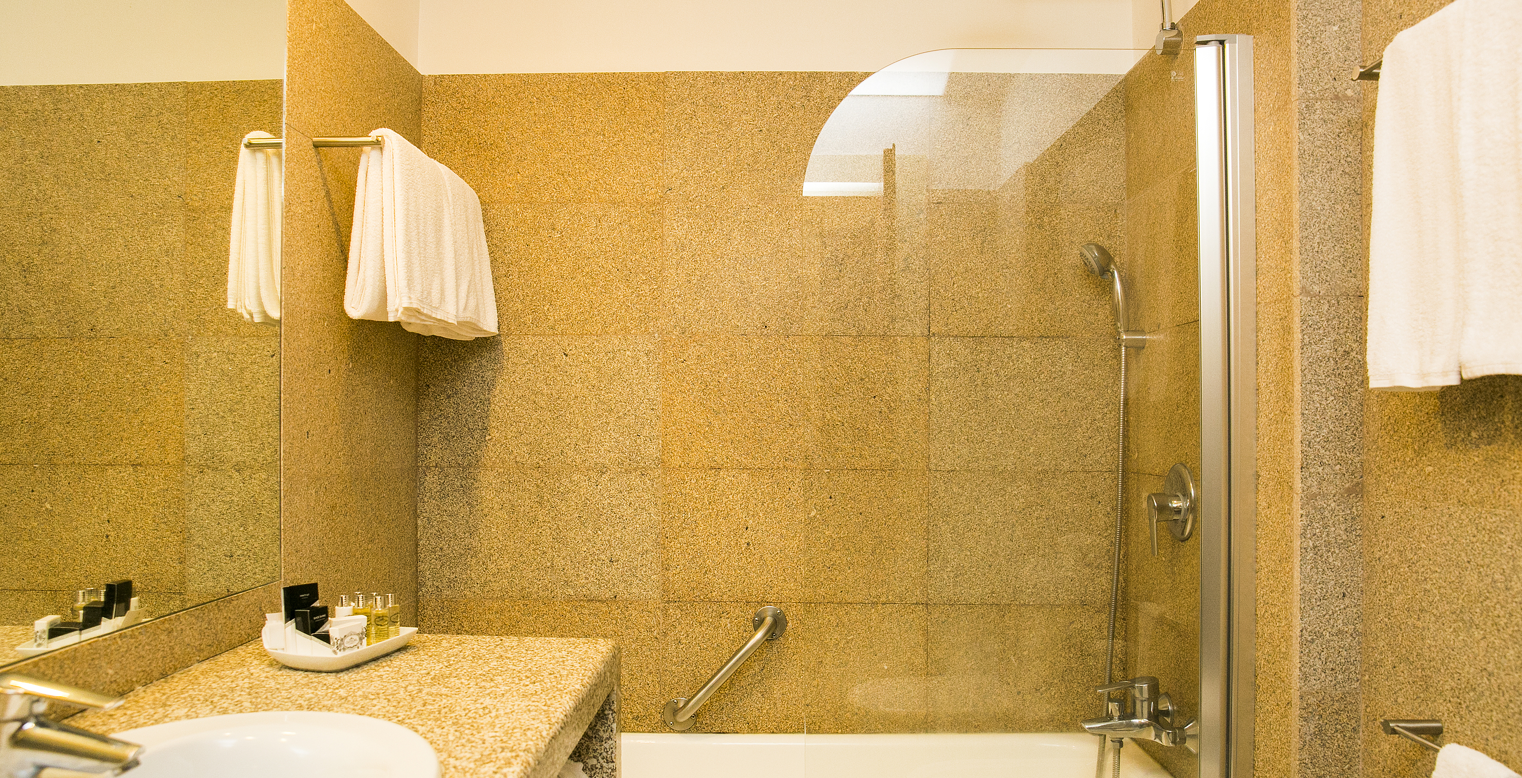 The Classic Room of The Pousada Mosteiro Guimarães has a bathroom with brown tones, a bathtub, and a sink