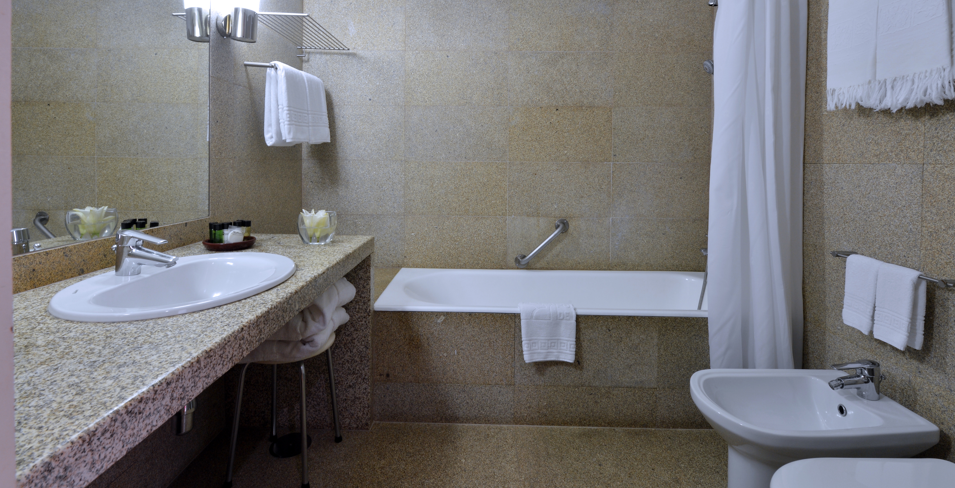 The Family Classic of The Pousada Mosteiro Guimarães has a bathroom with brown tones, a bathtub, and a sink