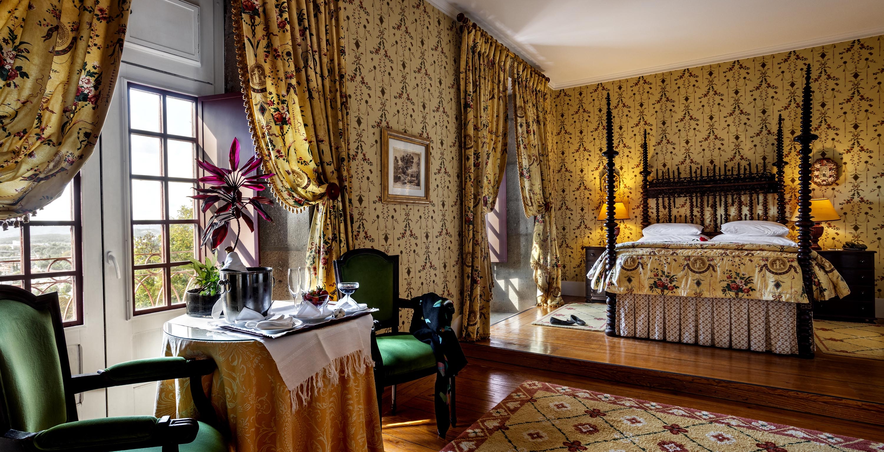 The Master Suite of The Pousada Mosteiro Guimarães has a double bed, two windows, and a table with two chairs