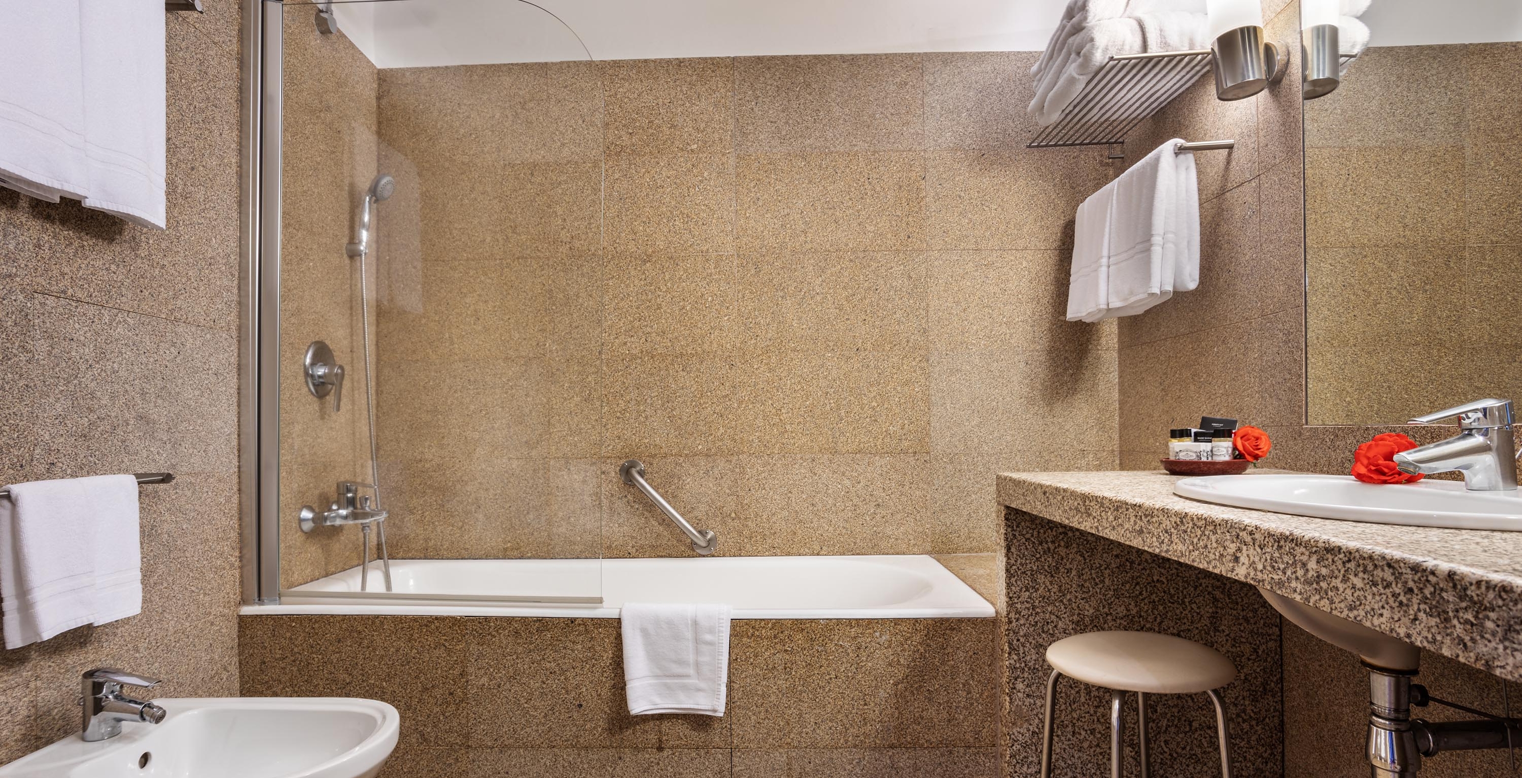 The Superior Room of The Pousada Mosteiro Guimarães has a bathroom with brown tones, a bathtub, and a sink