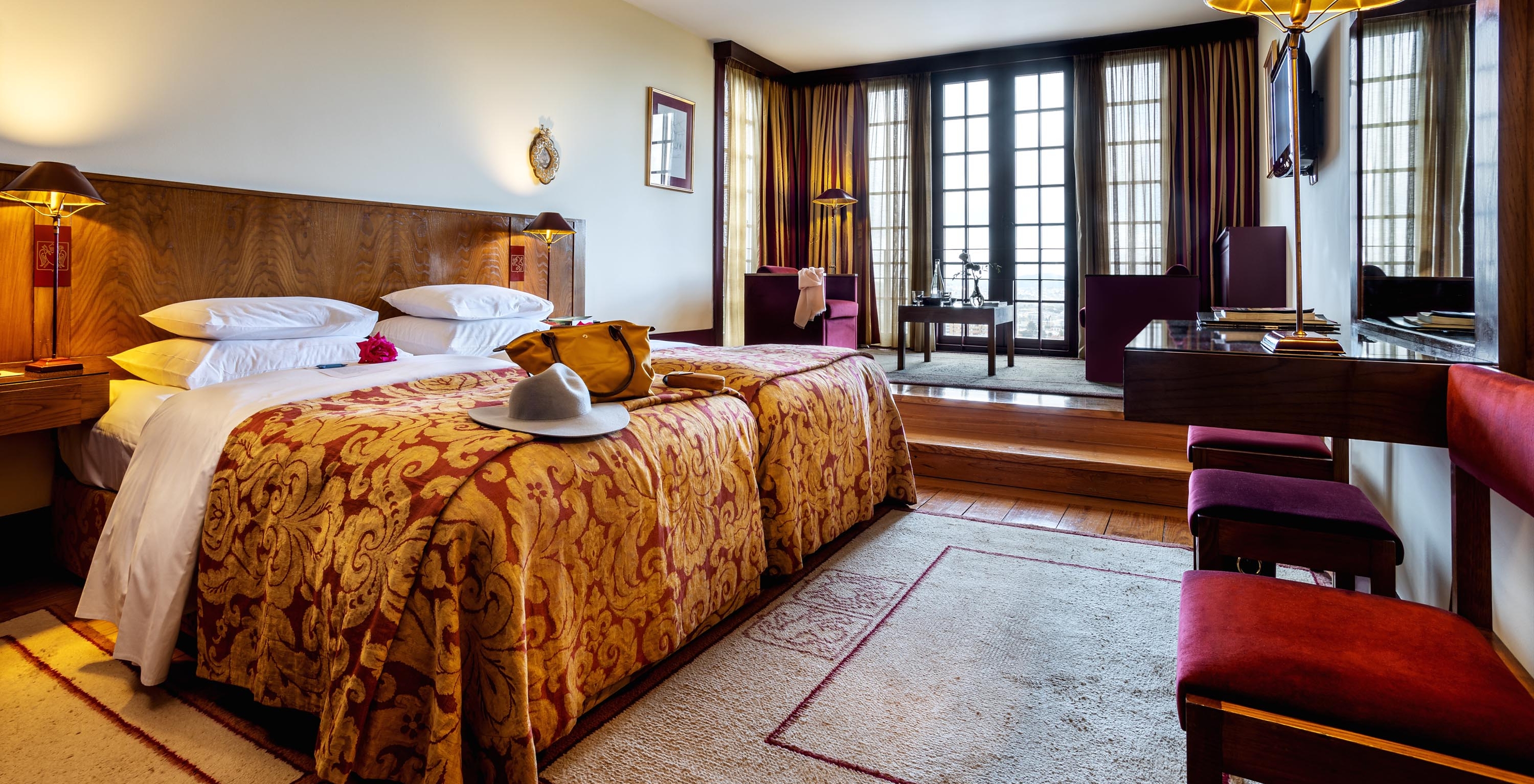 The Superior Room of The Pousada Mosteiro Guimarães has two separate beds, a television, and a large window