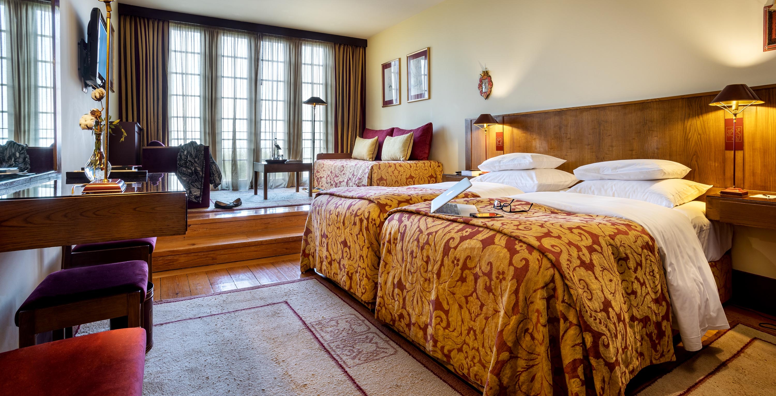The Family Superior of The Pousada Mosteiro Guimarães has two separate beds, a television, and a large window