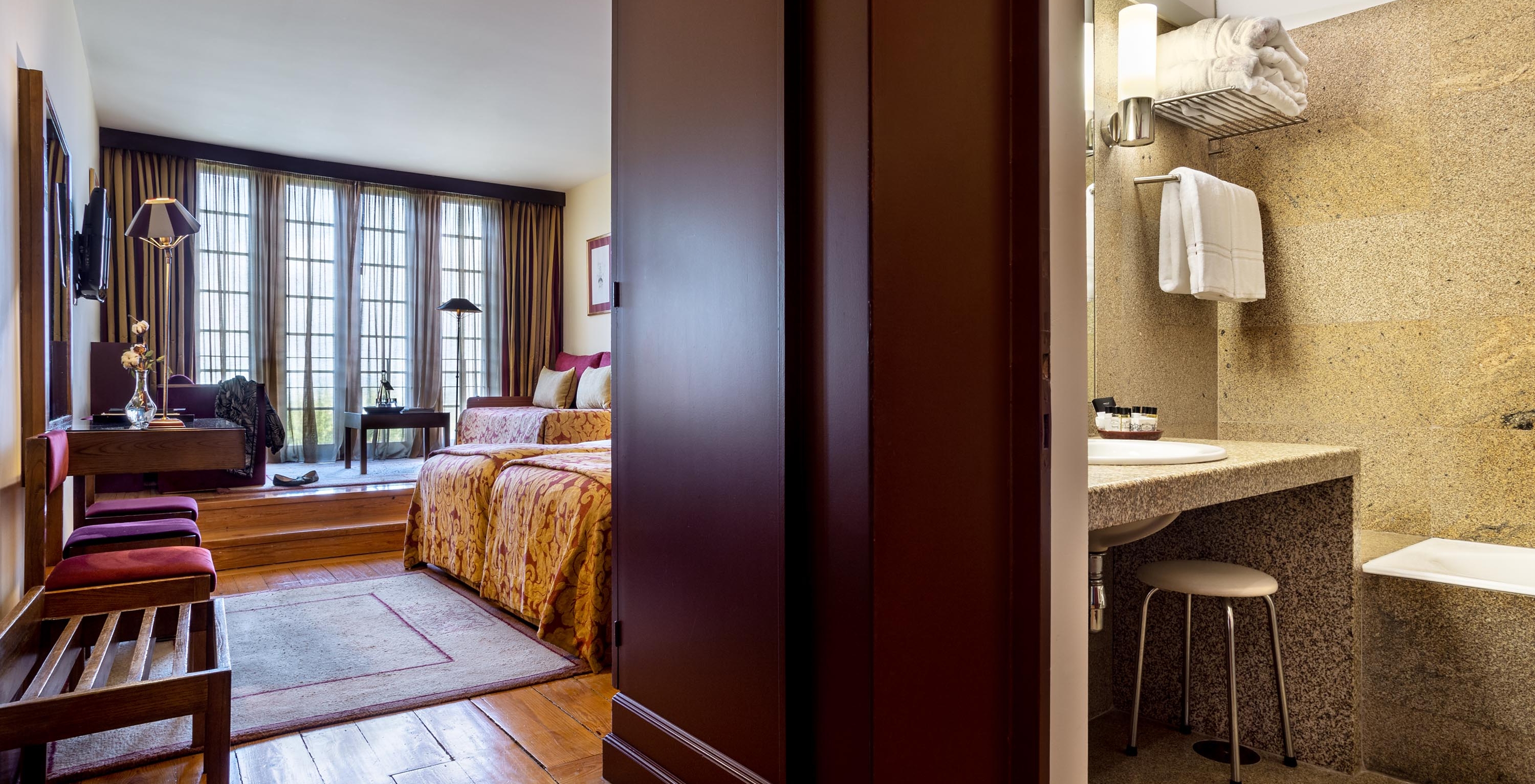 The Family Superior of The Pousada Mosteiro Guimarães has a bathroom with a sink, two separate beds, and a window