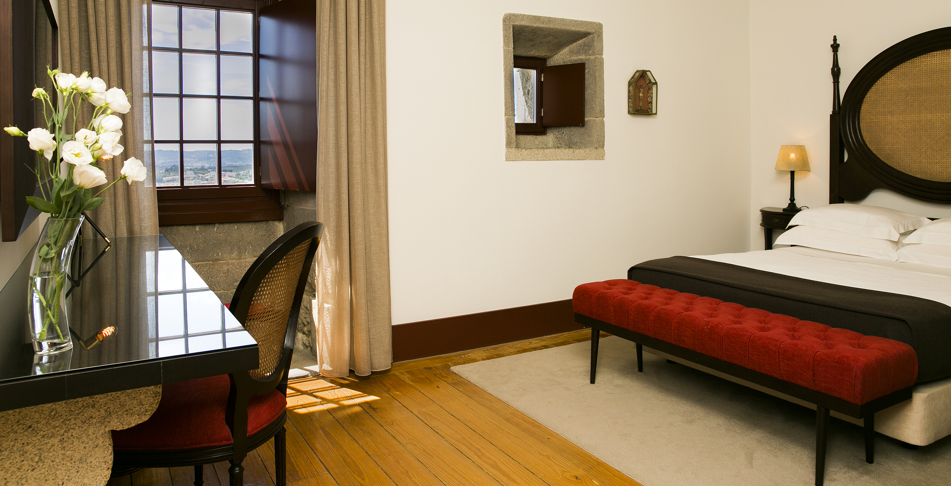 The Historical Superior of The Pousada Mosteiro Guimarães has a double bed with a dark wood and straw headboard