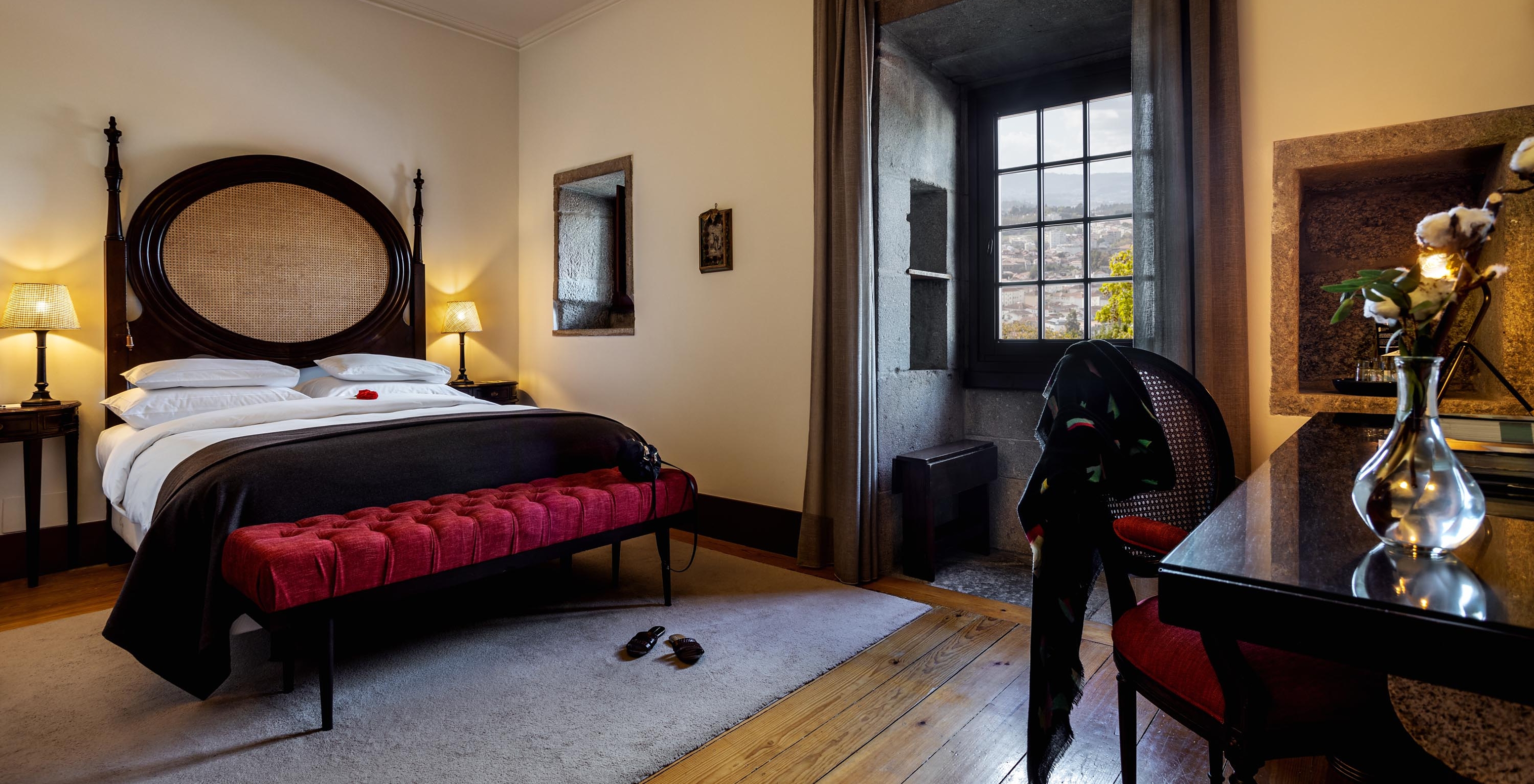 The Historical Superior of The Pousada Mosteiro Guimarães has a double bed with a dark wood headboard and a window