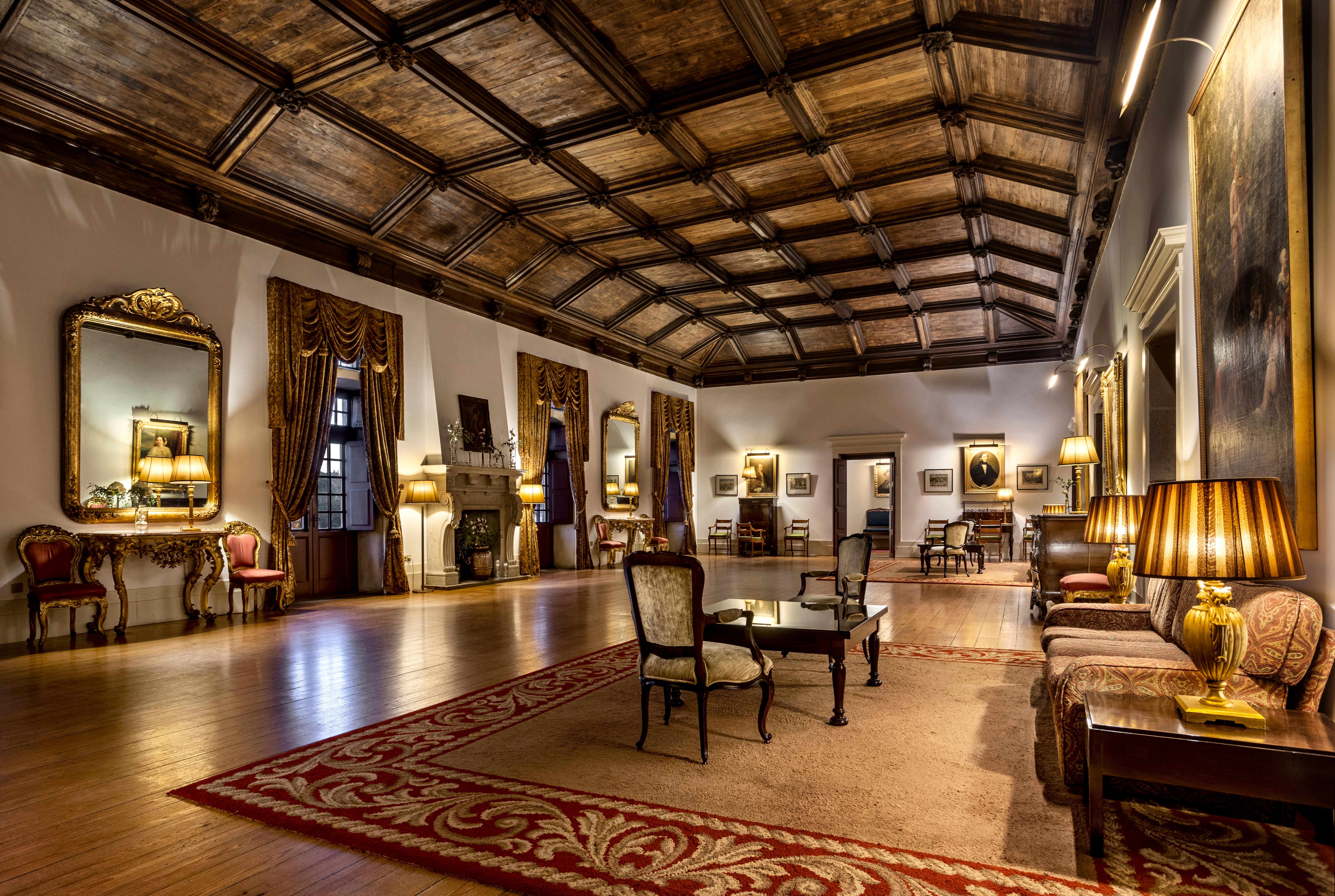 The Pousada Mosteiro Guimarães has a living room with a wooden ceiling and several sofas