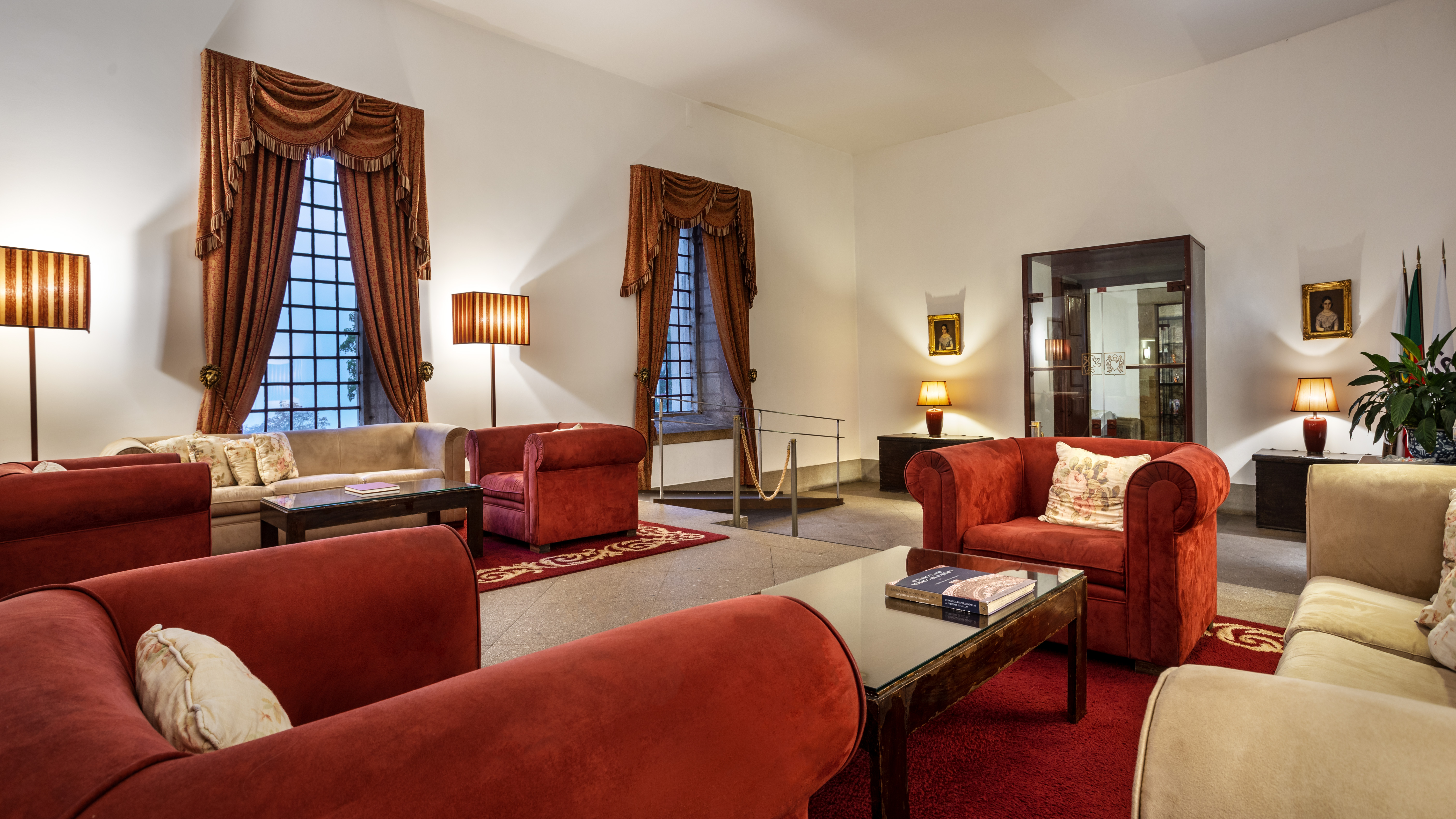 The Pousada Mosteiro Guimarães has a reception with beige sofas and red armchairs