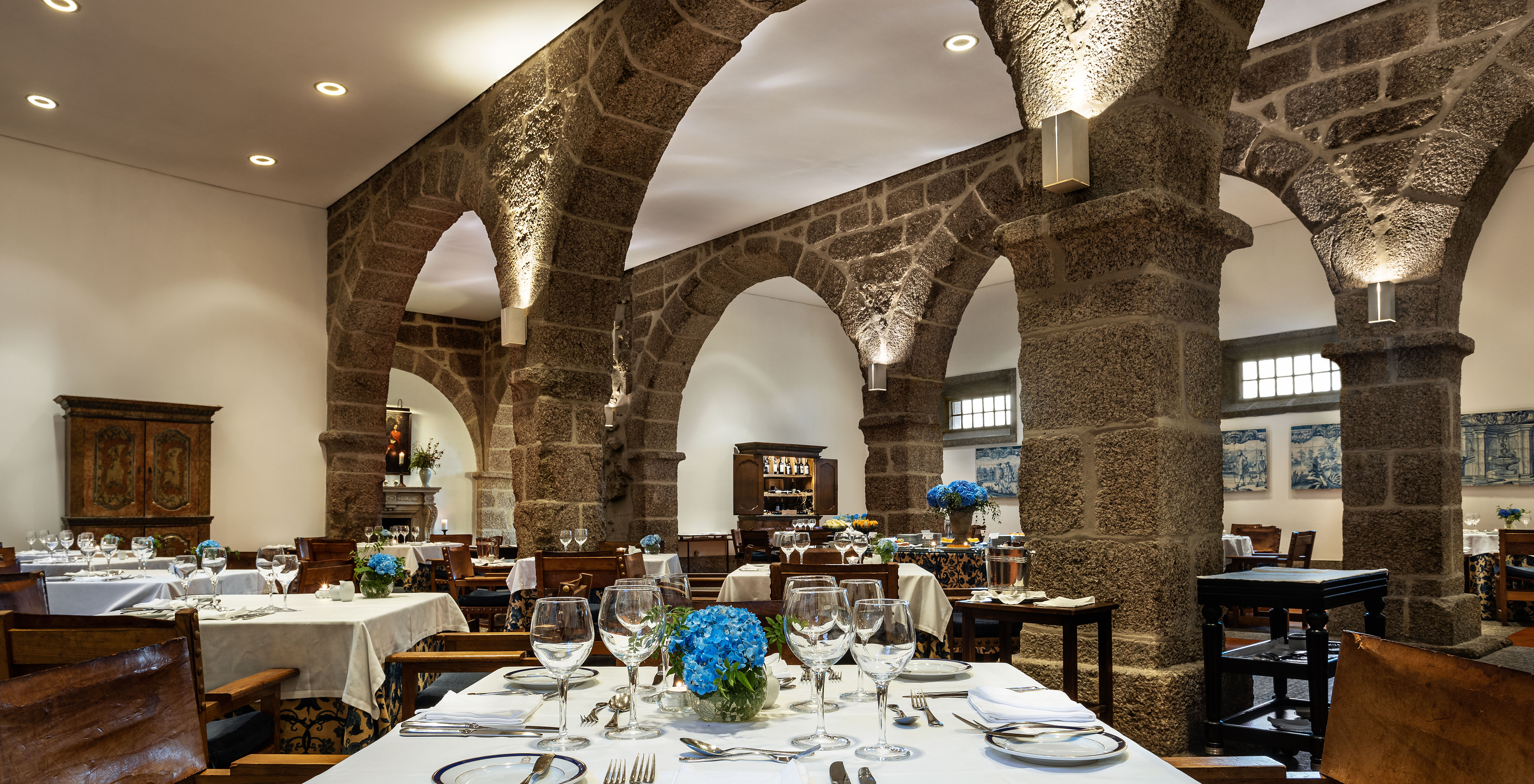 The D Mafalda restaurant at the Hotel in the Historic Center of Guimarães has tables with blue flowers and stone arches