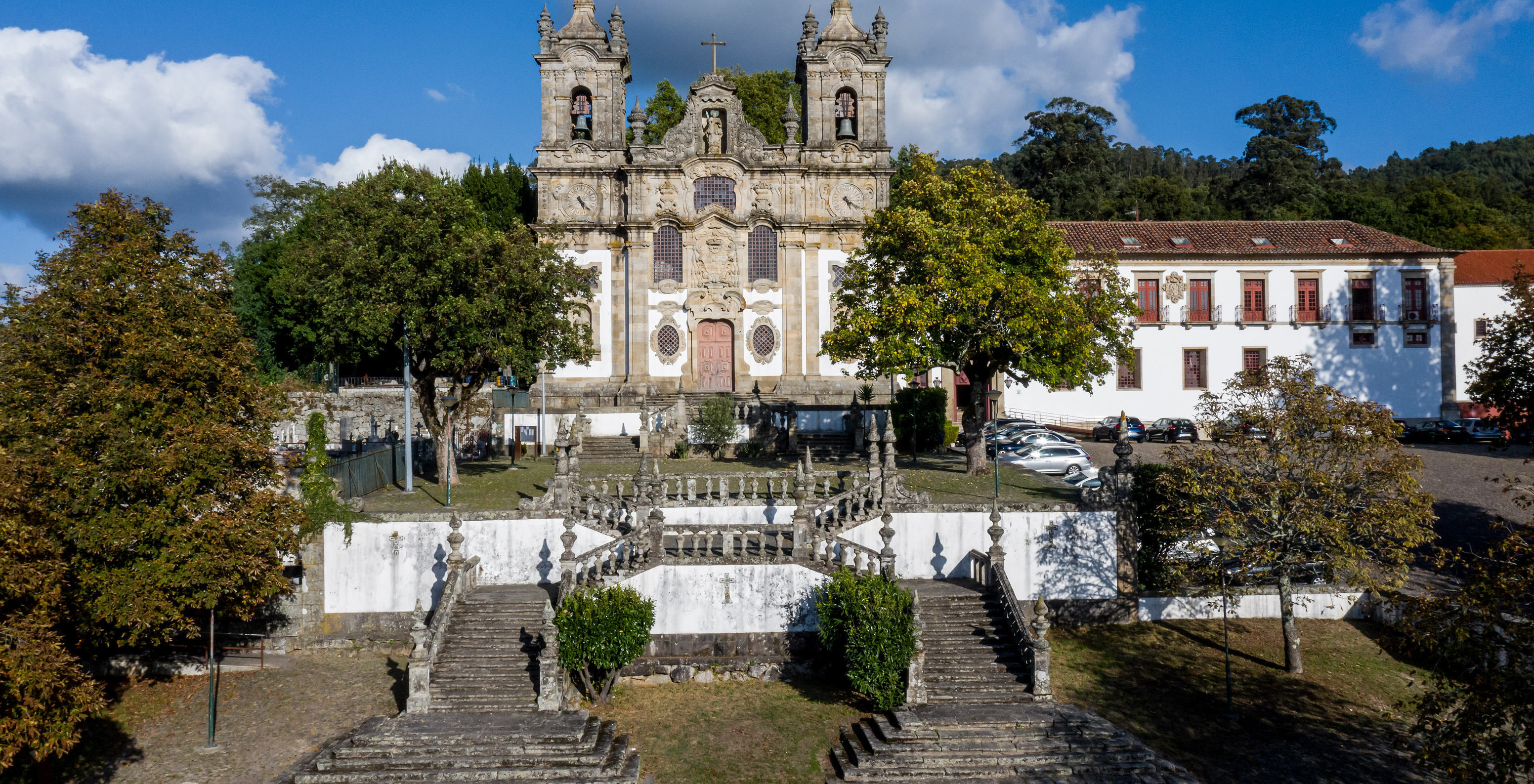 Pousada Mosteiro Guimarães, a hotel in Guimarães Historic Center, with two towers, a cross, and a staircase