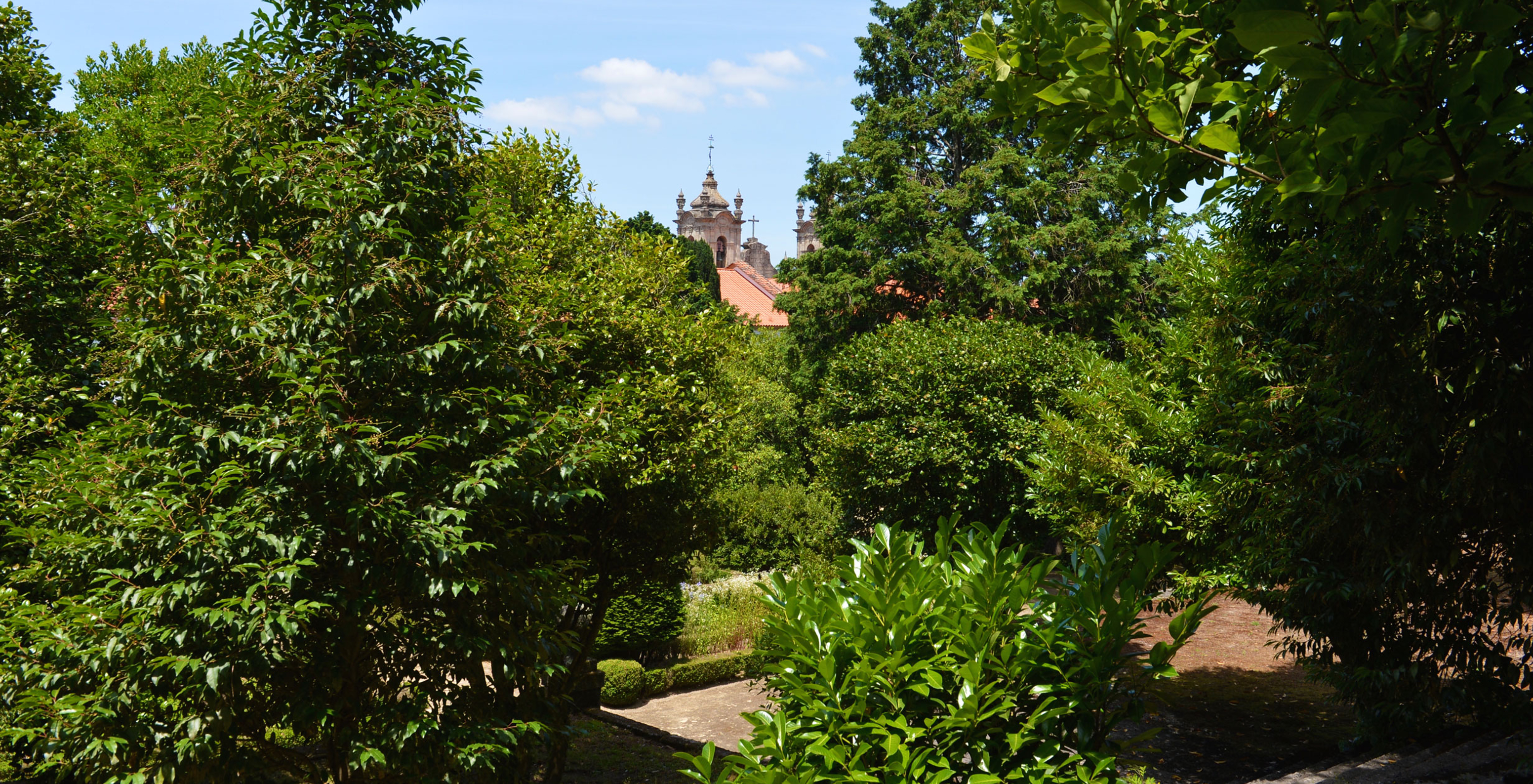 Pousada Mosteiro Guimarães, a hotel in Guimarães Historic Center, with several trees and a church in the background