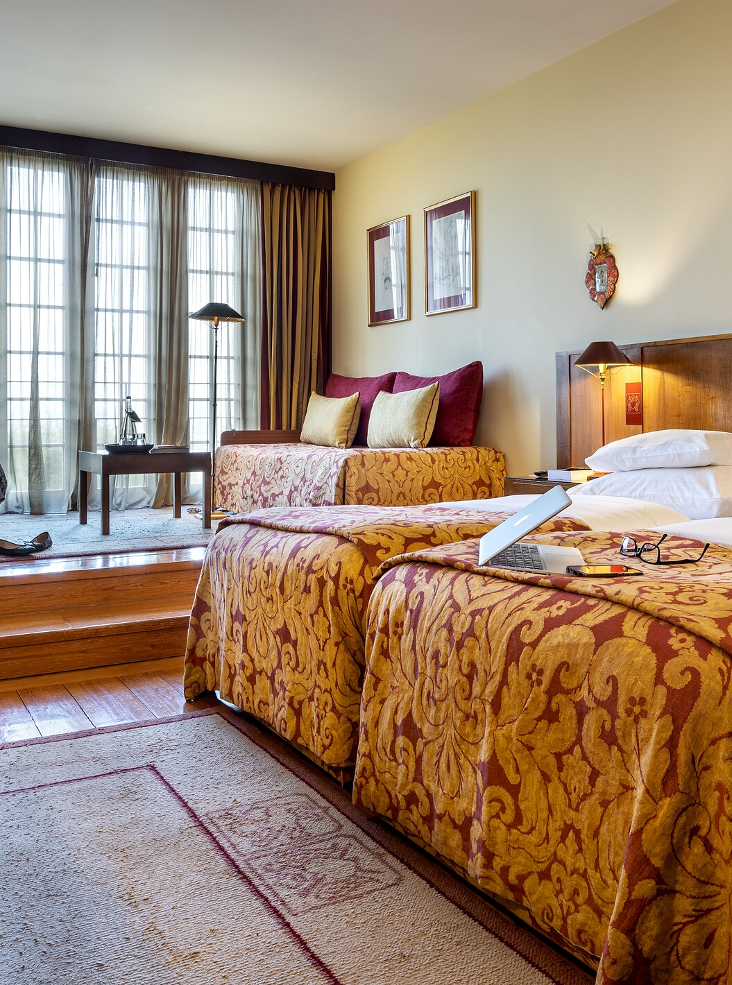 The Classic Family at Pousada Mosteiro Guimarães is a spacious room with two large beds together and two sofas.