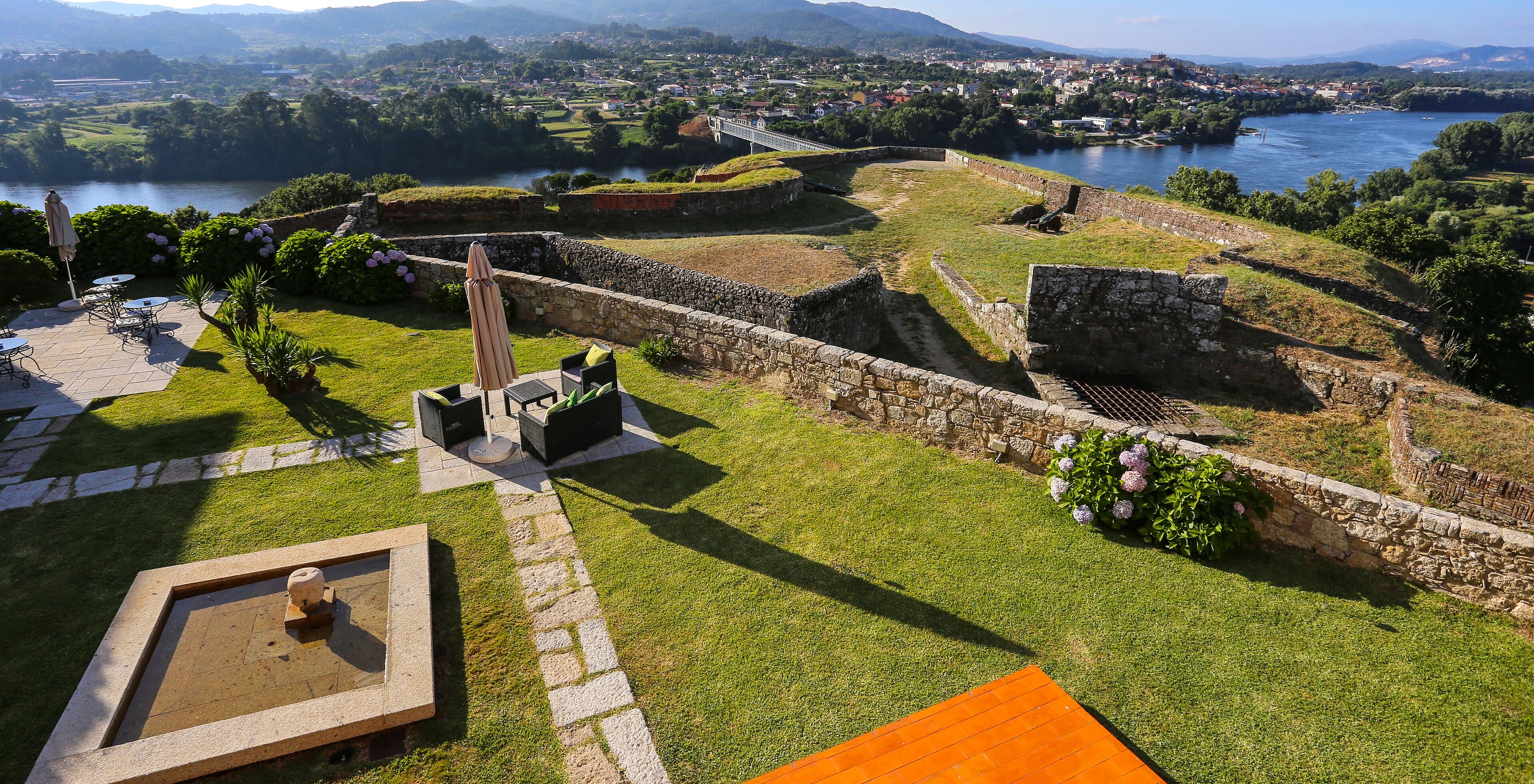 Aerial view of Pousada Valença gardens, a Charming Hotel by river with sofas, umbrellas