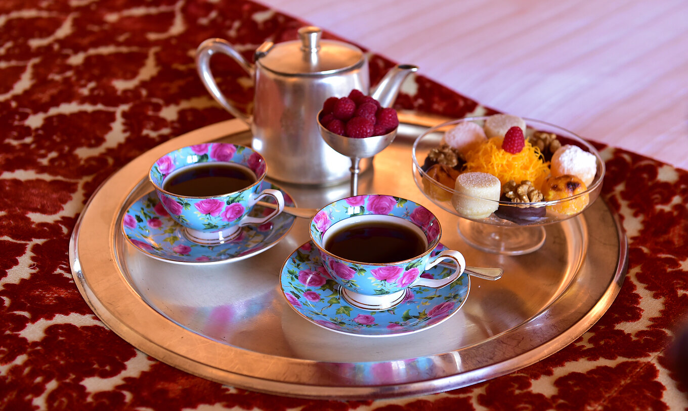 The Classic Room of The Pousada Valença has a room service tray with tea, fruit, and cookies