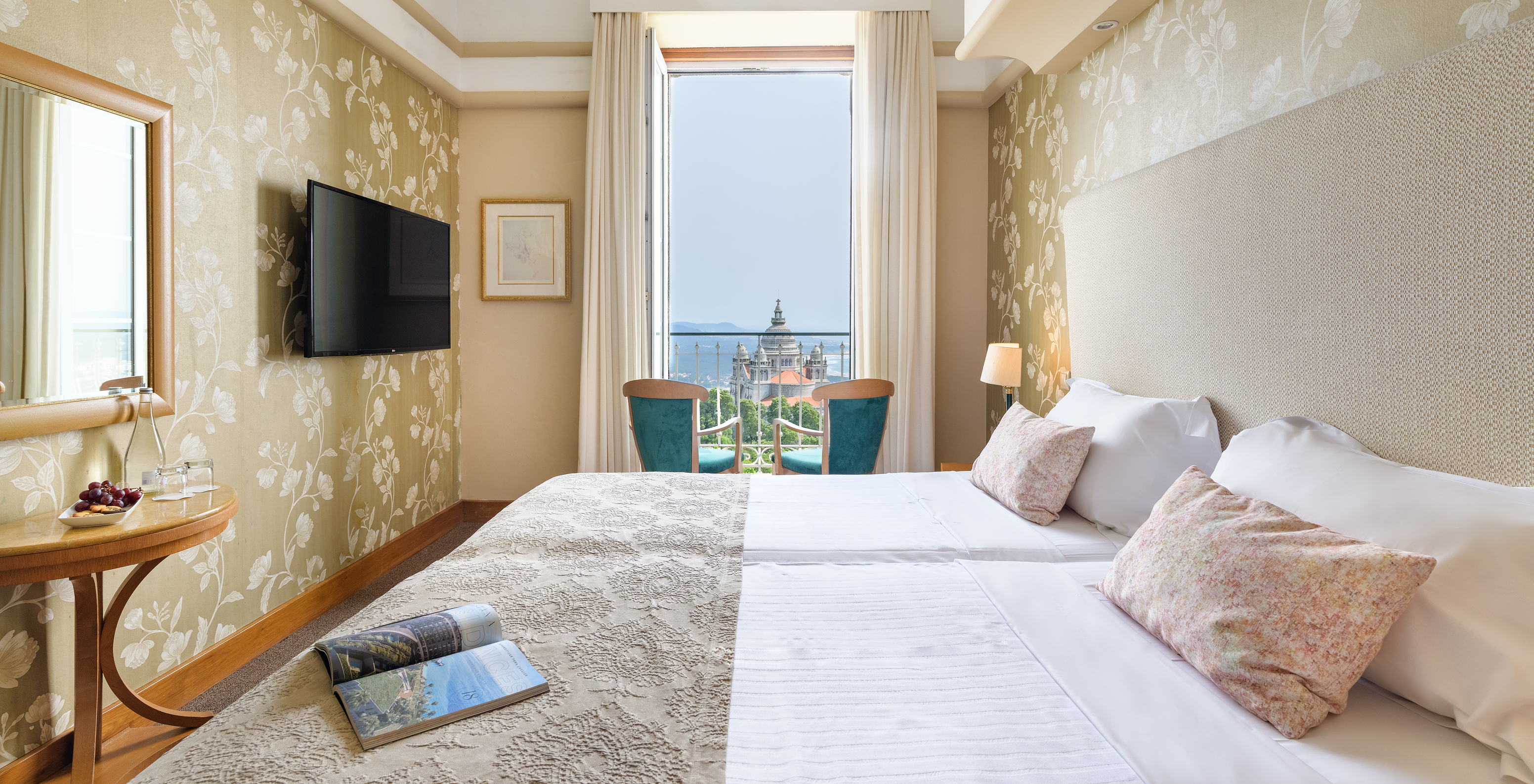The Superior Room of The Pousada Viana do Castelo has two chairs by the window with a view of The Basilica of Santa Luzia