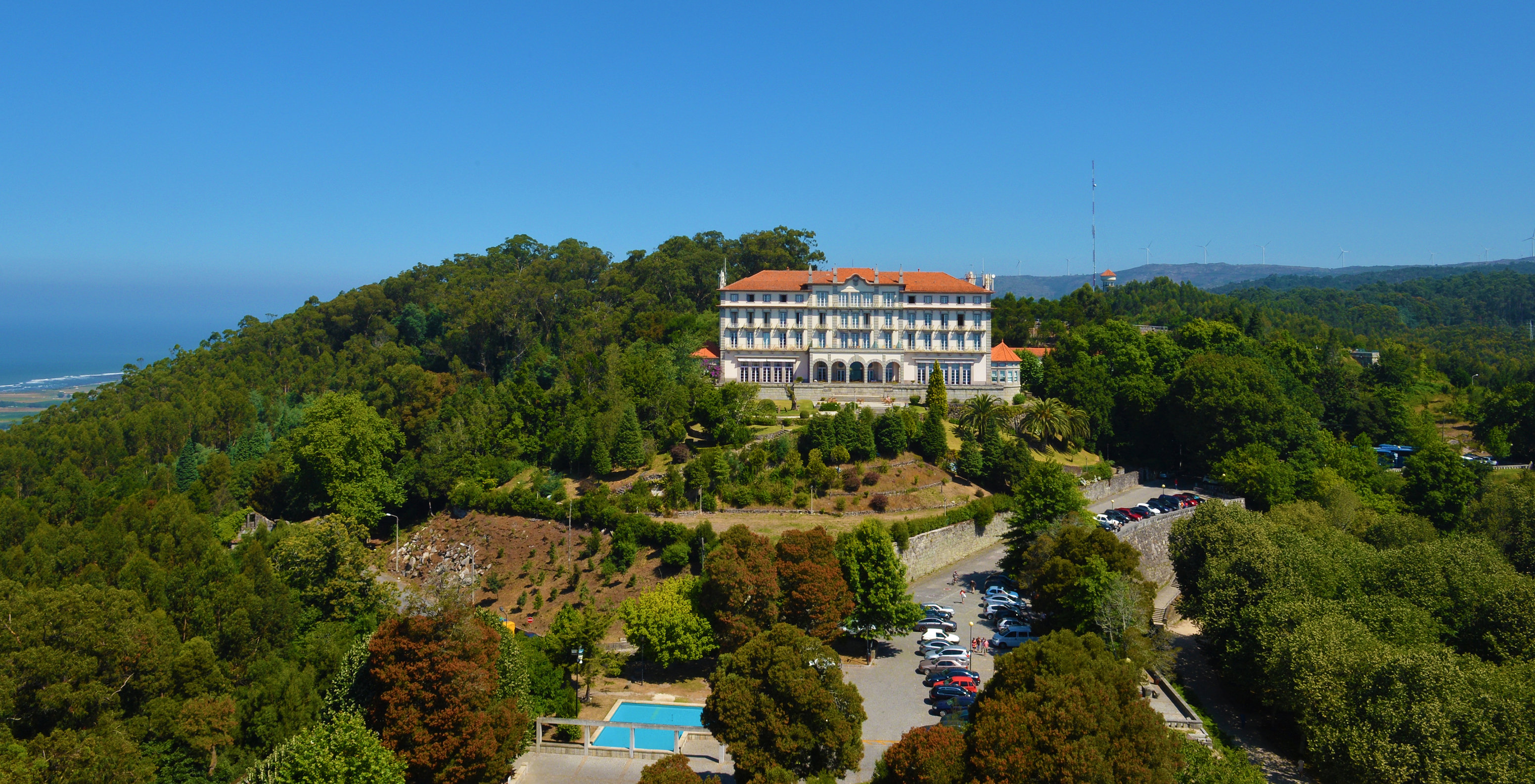 Drone view of Pousada Viana do Castelo, surrounded by greenery with parking nearby