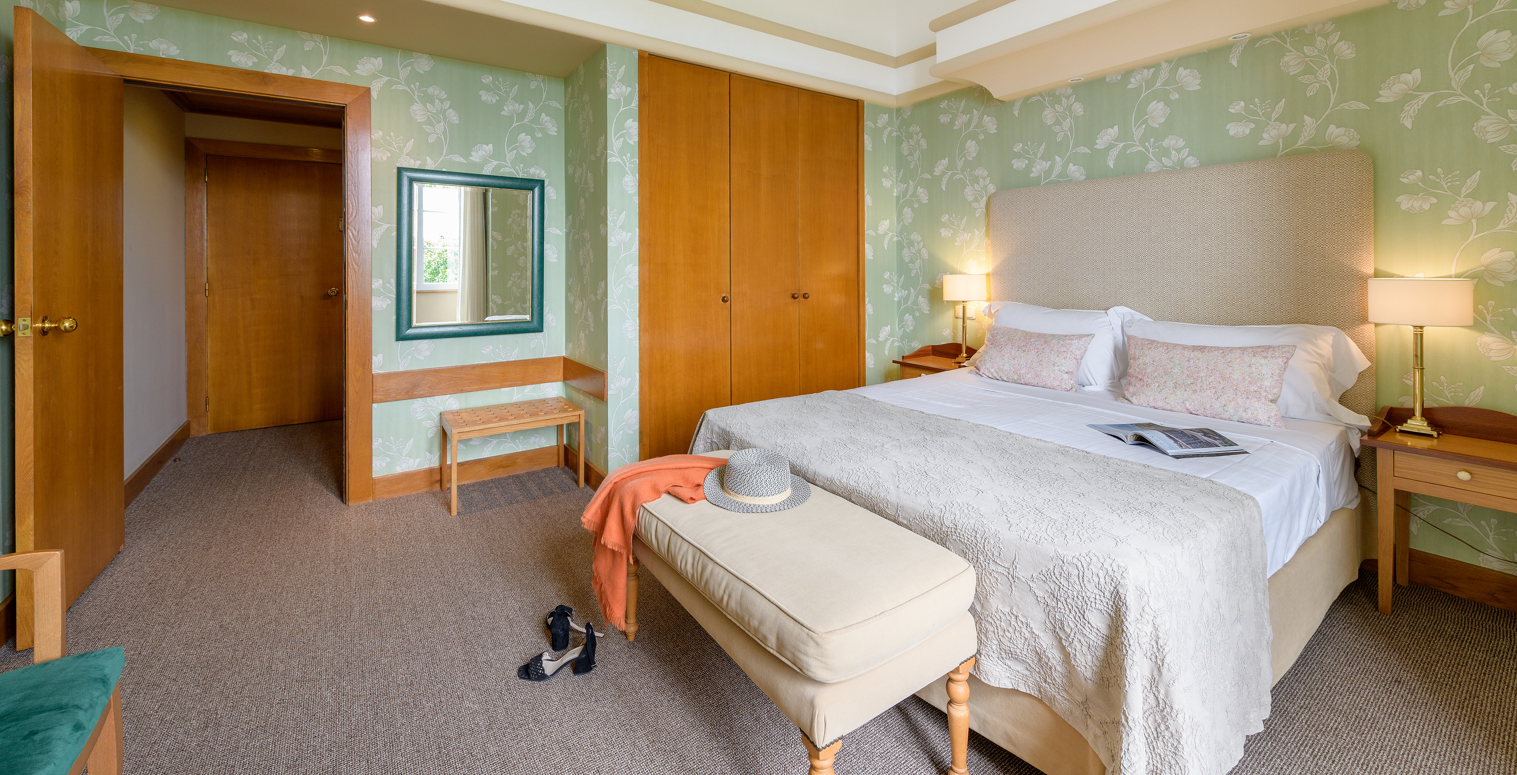 The Classic Room of The Pousada Viana do Castelo has walls decorated with flowers in green tones, a bed, and a wardrobe