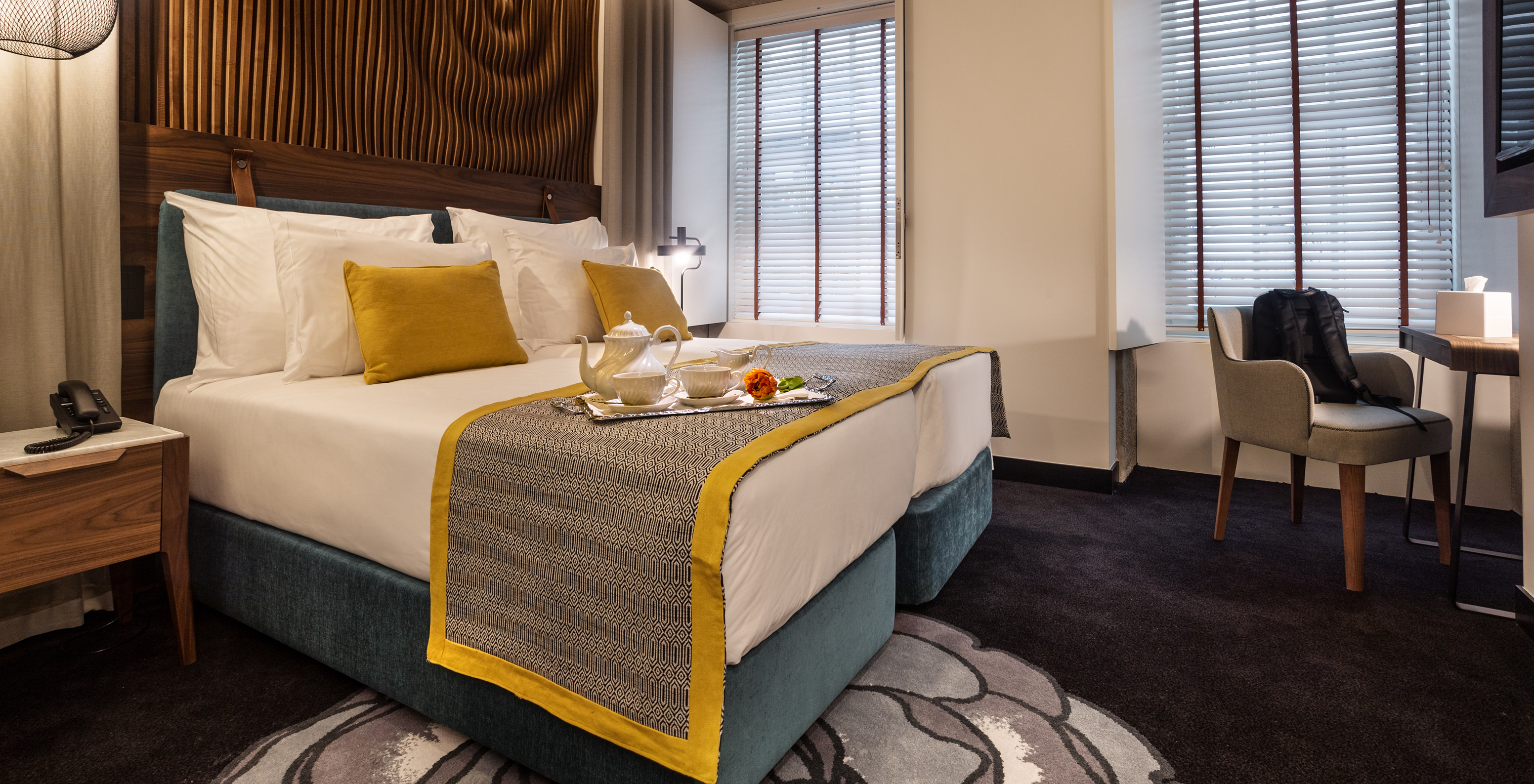 The Classic Room of The Porto Inn - Rua das Flores has a turquoise double bed, white sheets, and a wooden headboard