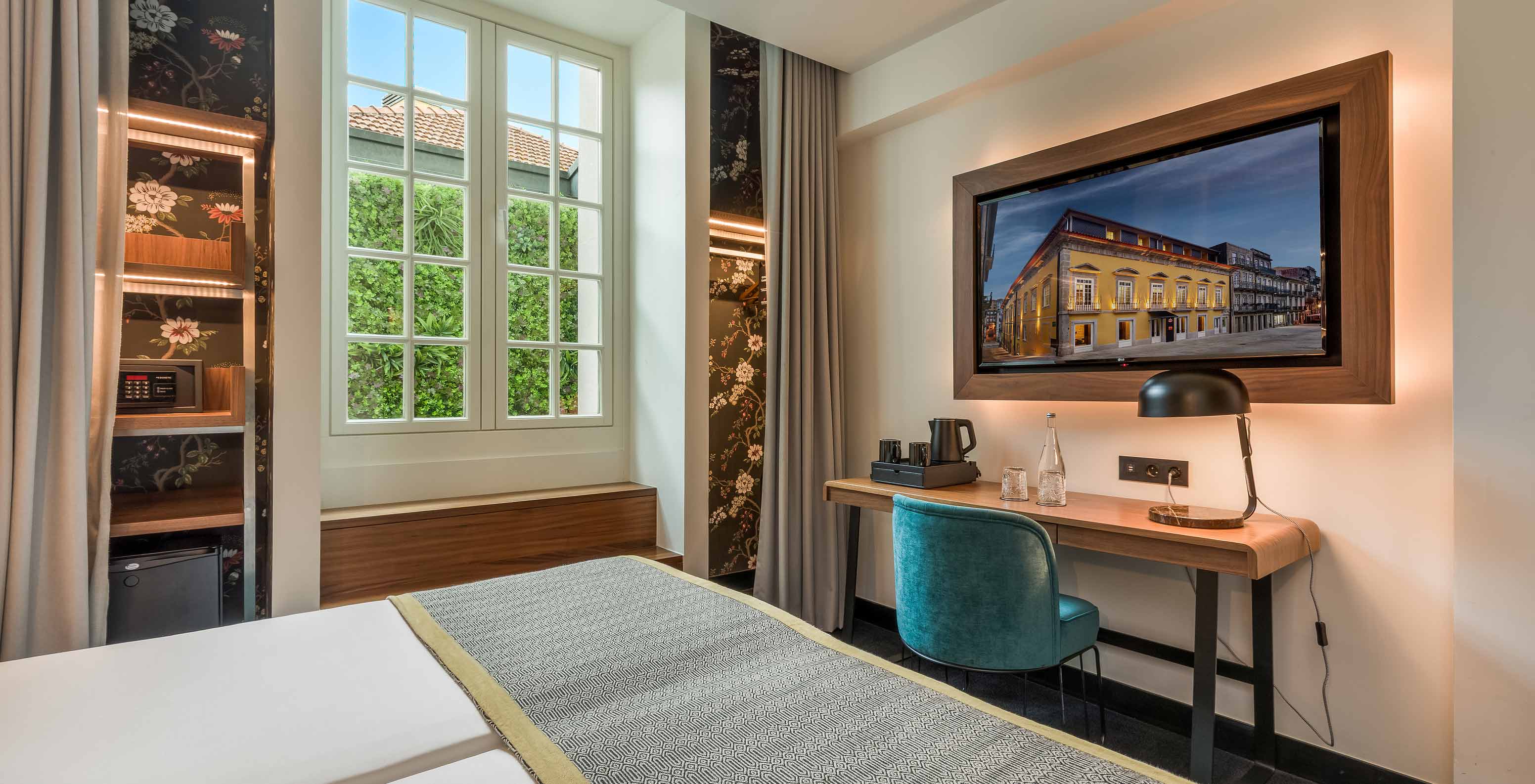The Cozy Room at Pousada Porto - Rua das Flores has a desk at the foot of the bed and a television on top.