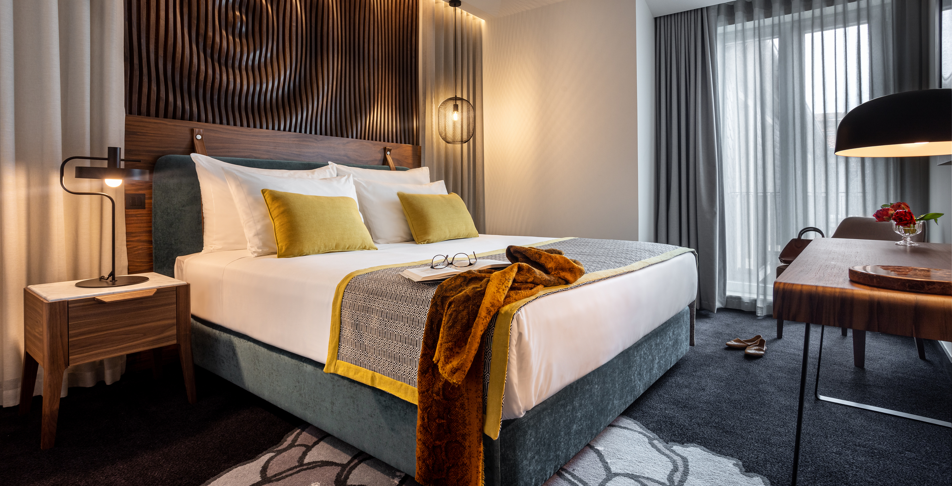 The Junior Suite of The Porto Inn - Rua das Flores has a turquoise double bed, white sheets, and a wooden headboard